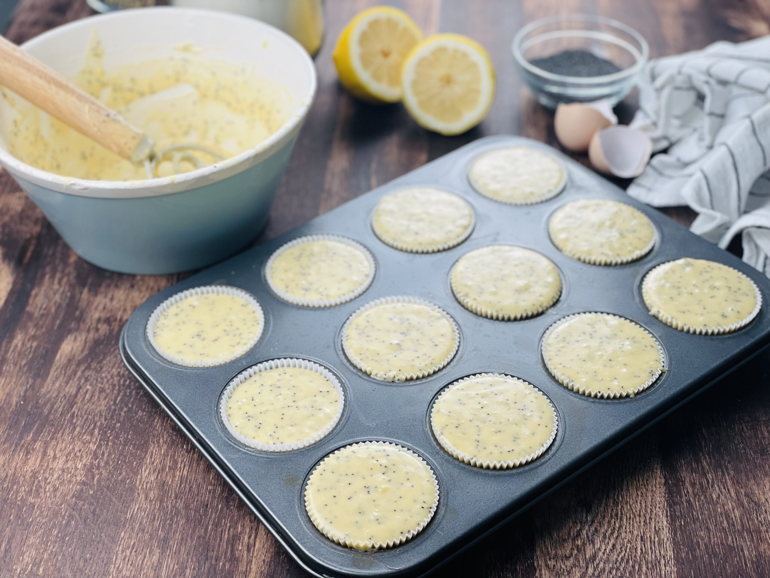 Sauerteig Zitronen-Mohn Muffin Teig in die Muffin Förmchen geben.