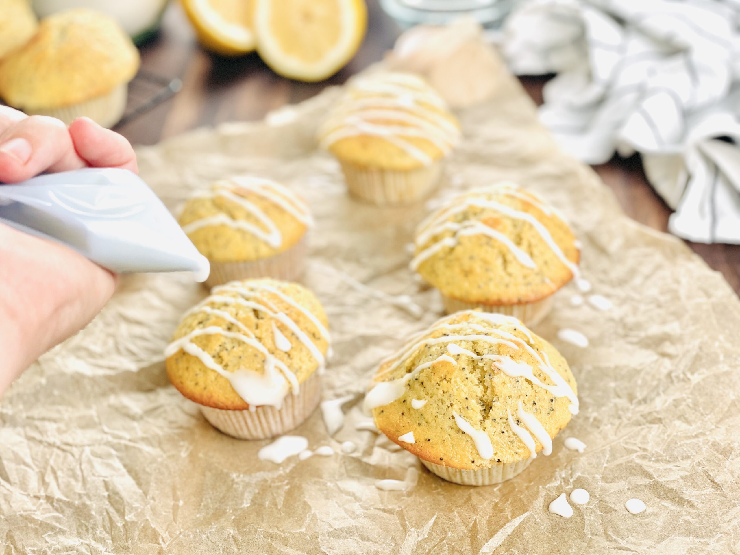 Glasur über die Zitronen-Mohn Sauerteig Muffins geben. 