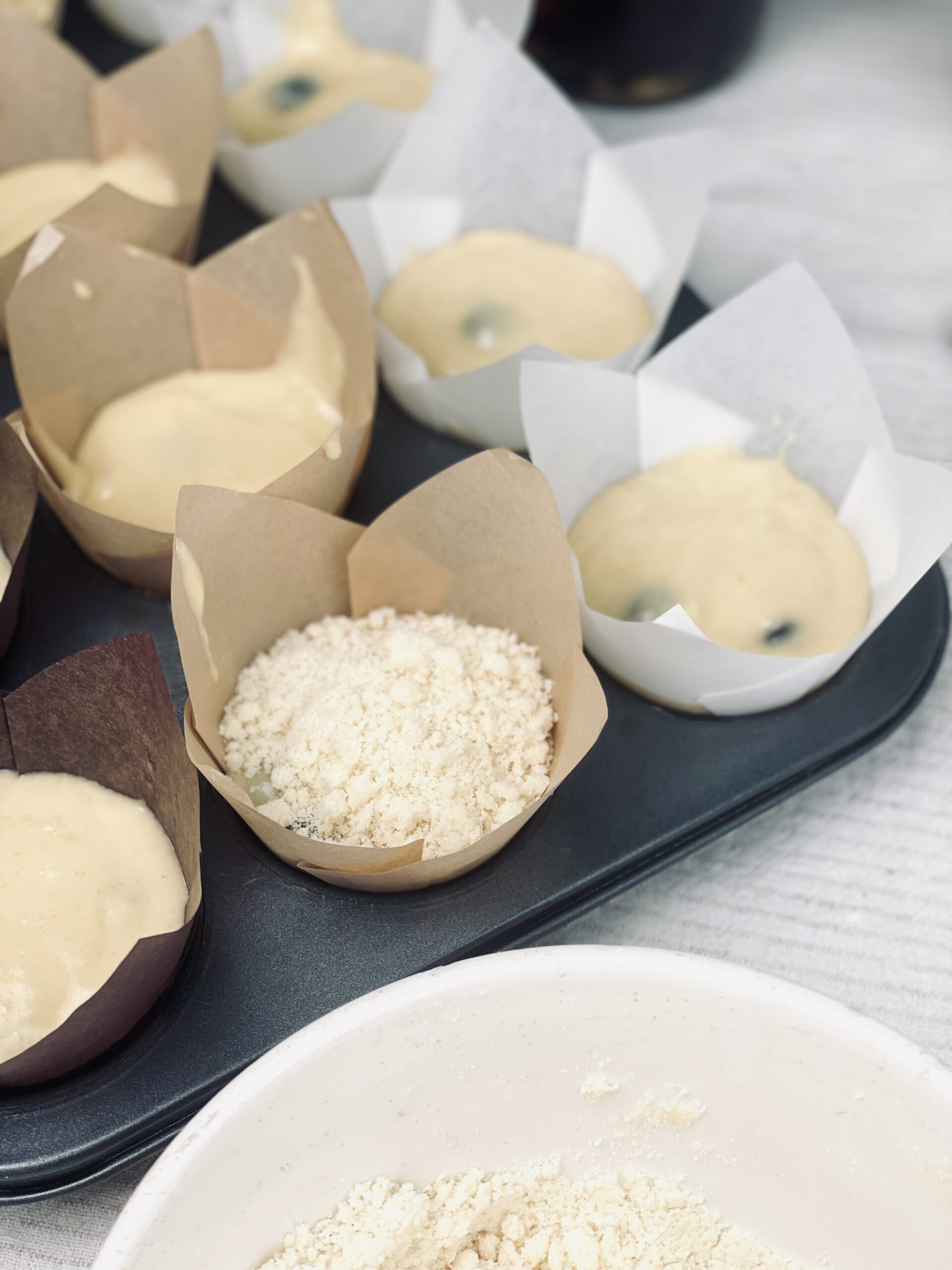 Streusel über die Sauerteig Blaubeer-Muffin geben