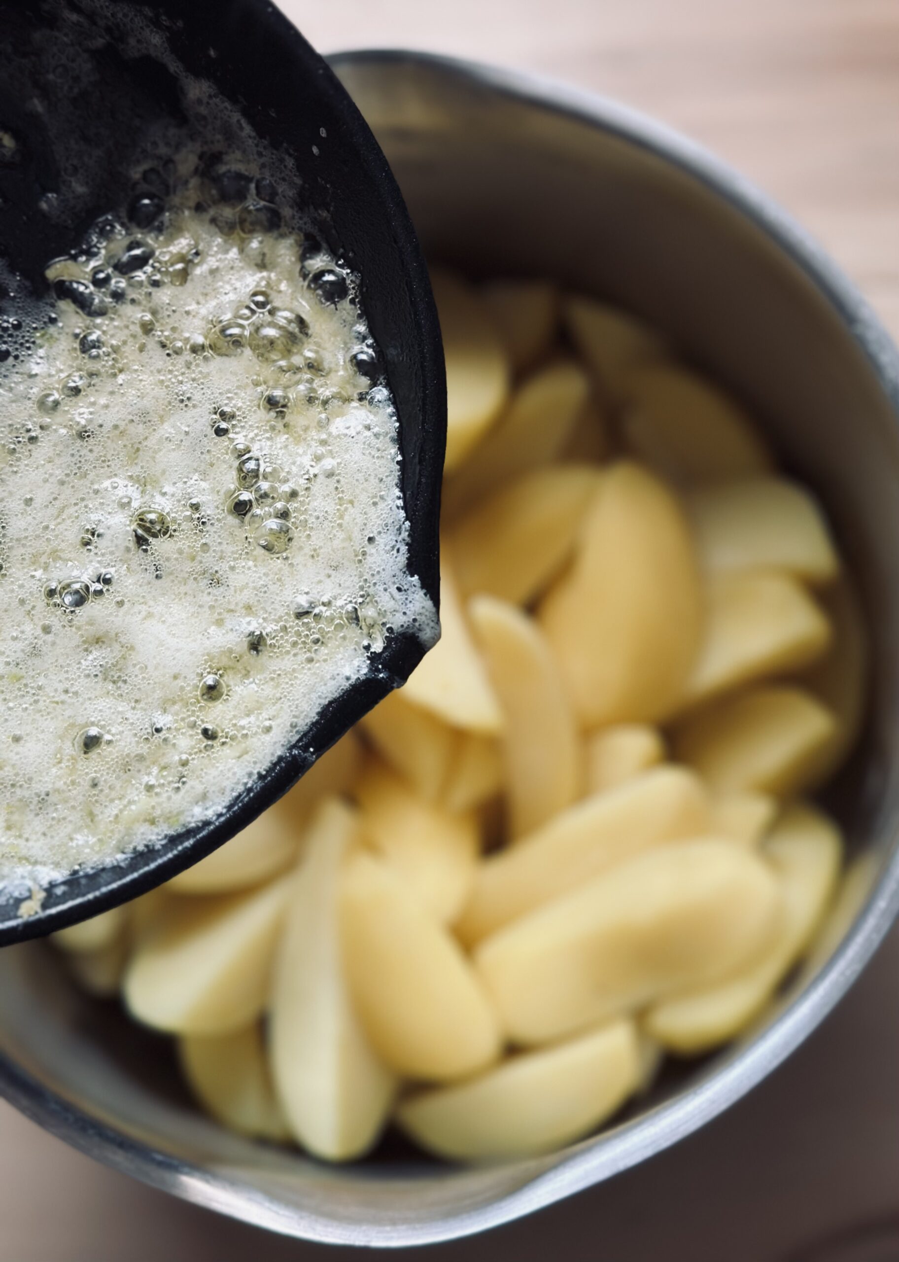 Zerlasse Butter mit Knoblauch über die Kartoffeln geben