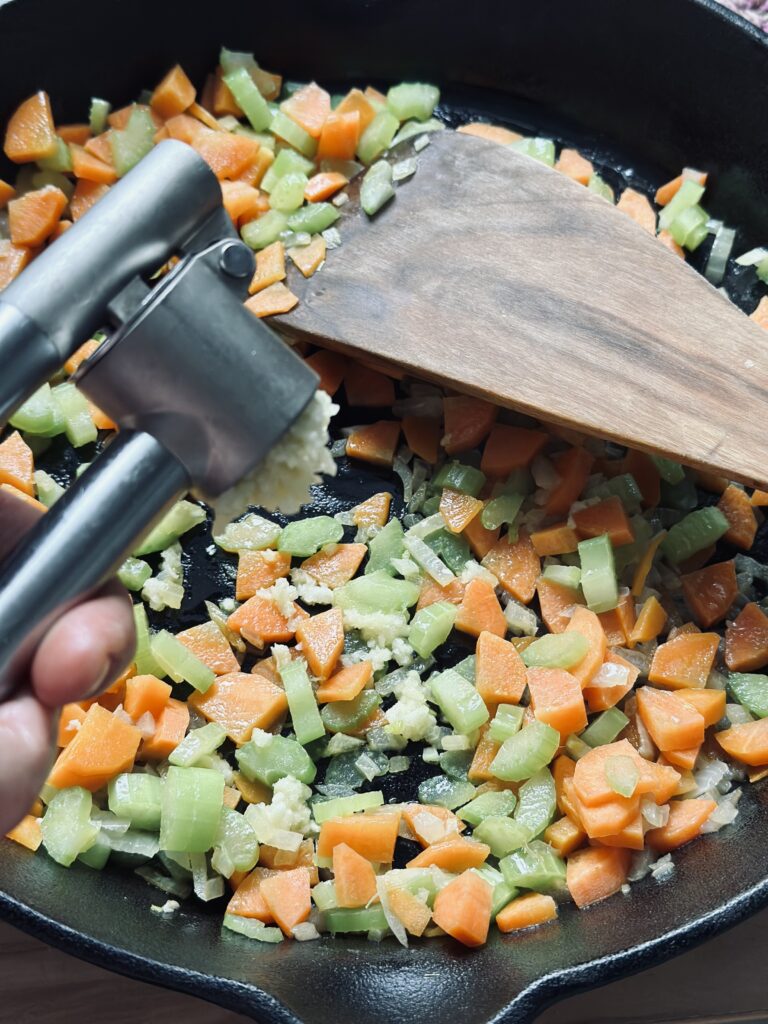 Knoblauch zu dem Shepherd's Pie Gemüse hinzufügen