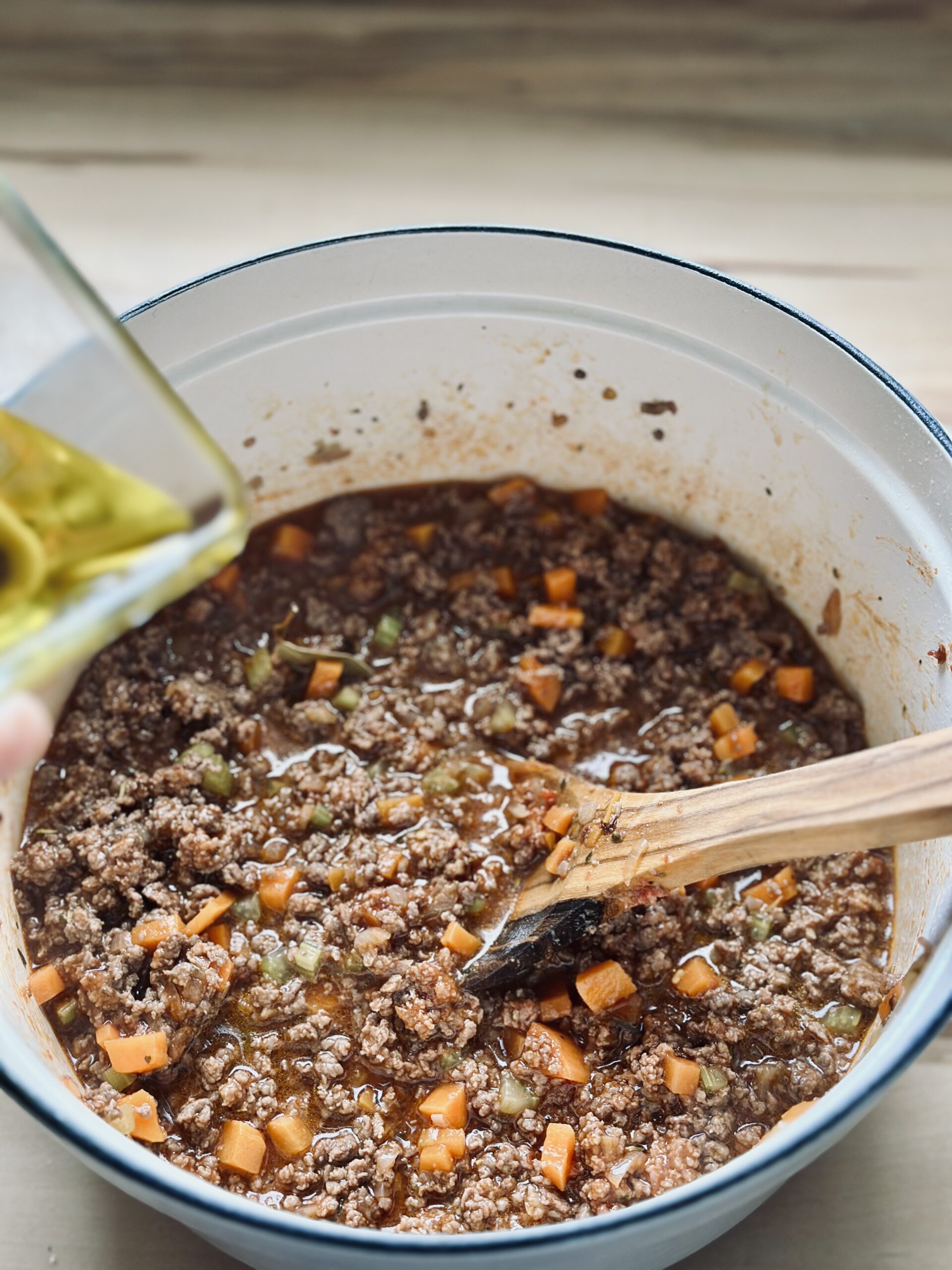 Ggf. Olivenöl zu der Bolognese Soße geben.