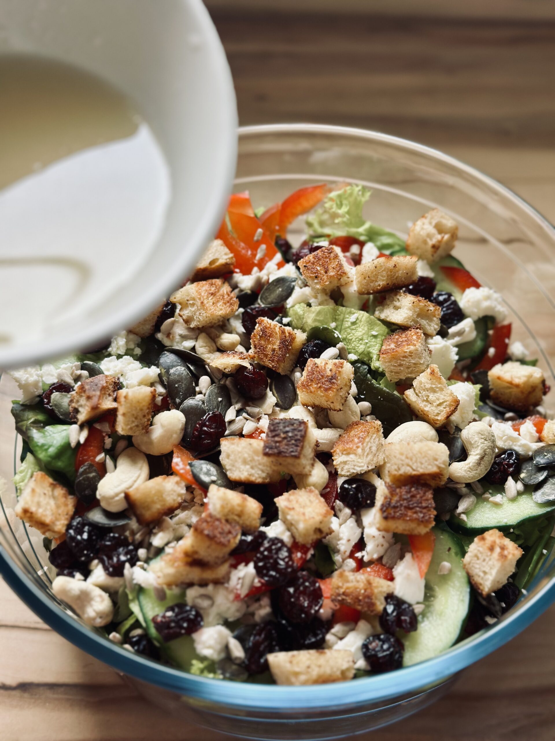 Salatsoße über den Salat geben