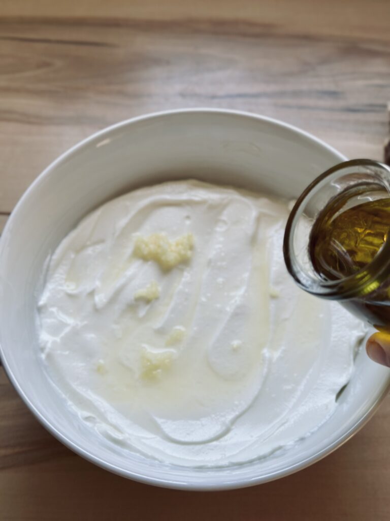 Olivenöl zu dem Tzatziki hinzufügen