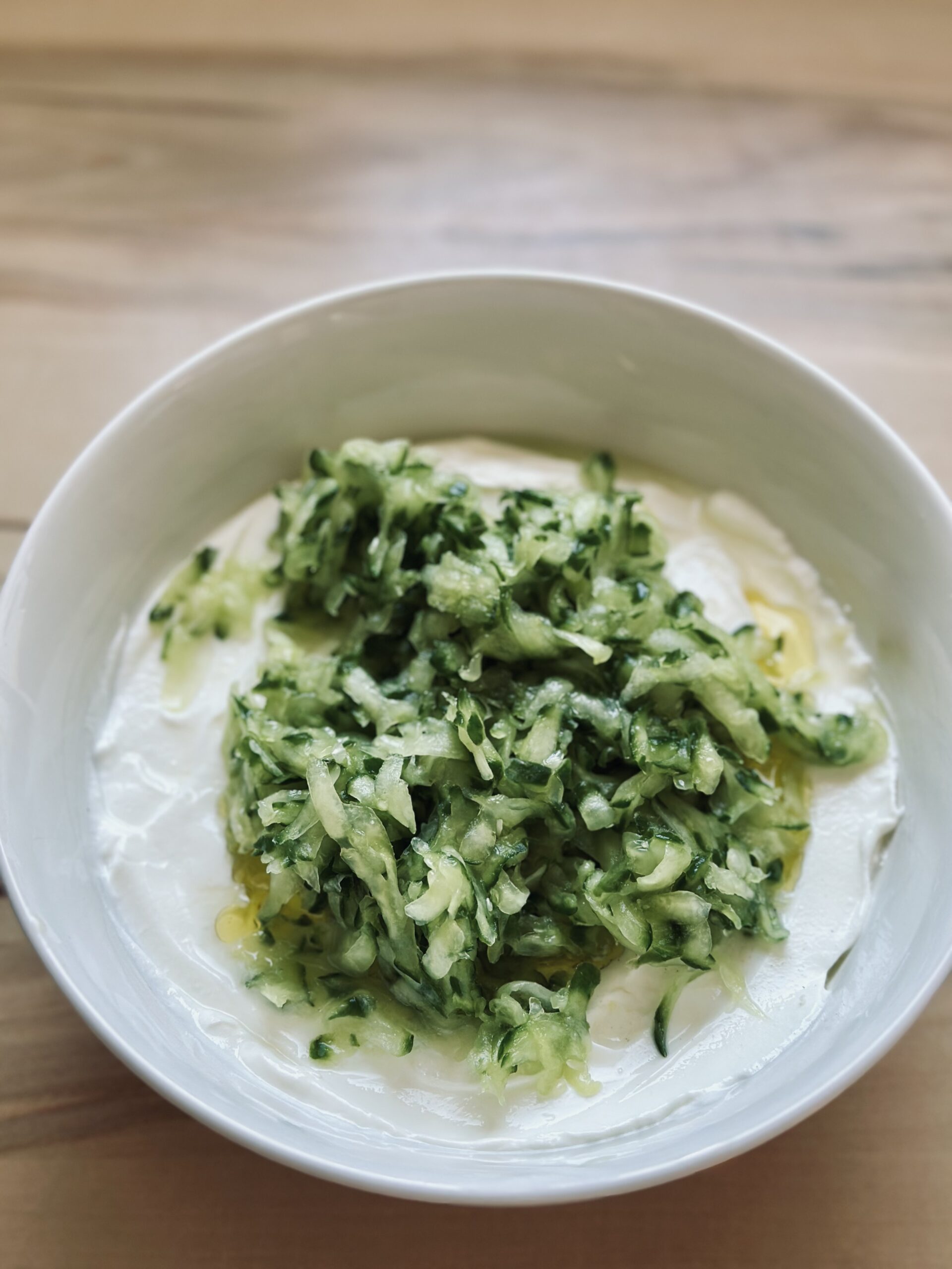 Gurken in das Tzatziki geben