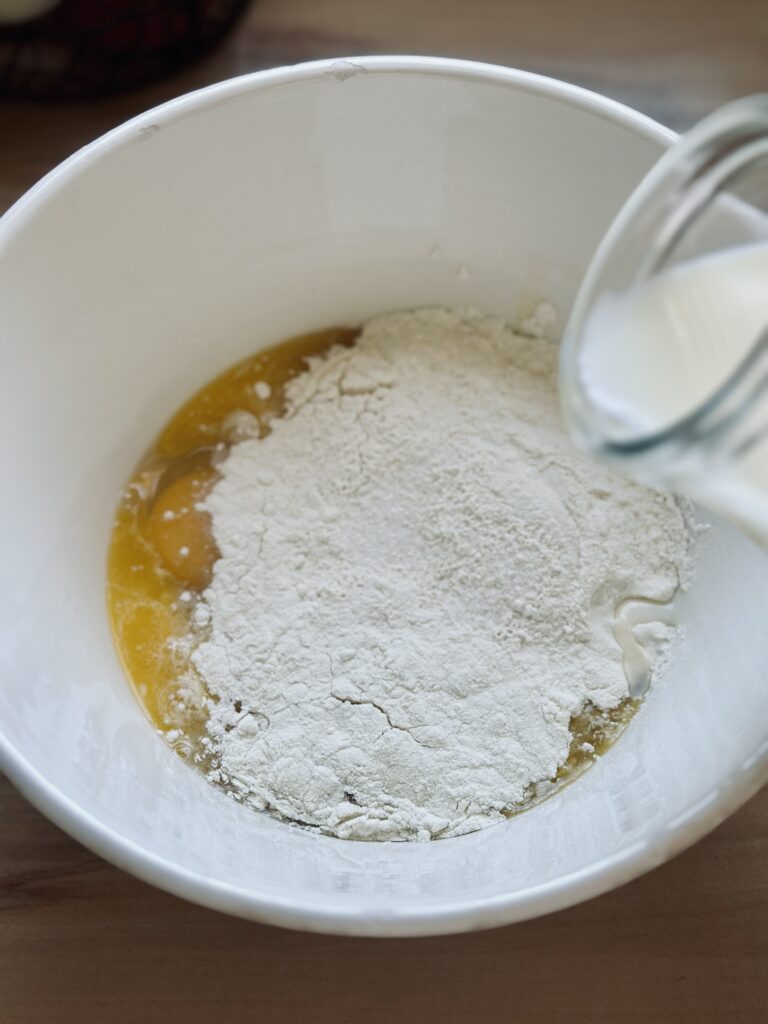 Milch zu dem Crepes Teig hinzufügen