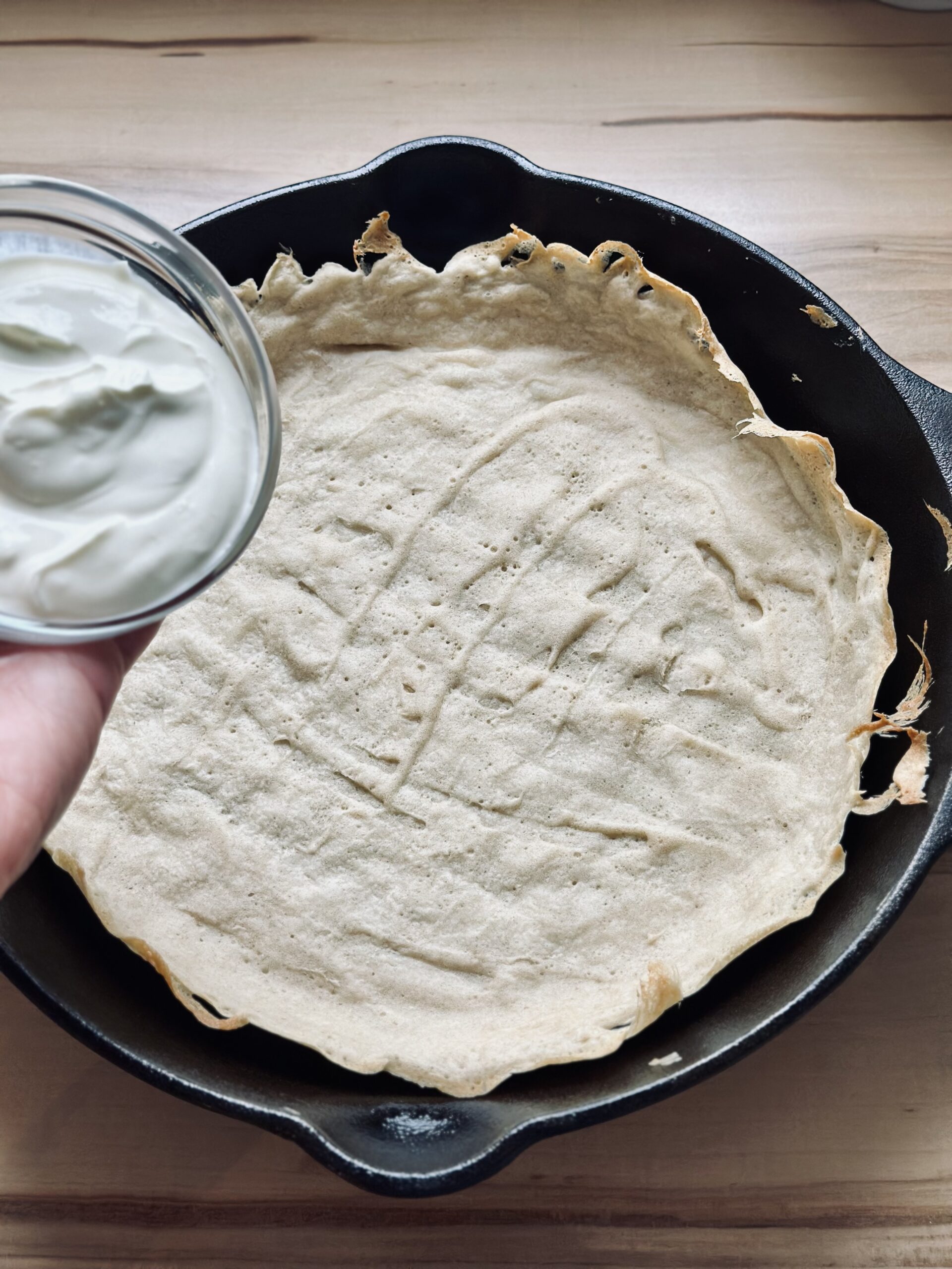 Flammkuchen mit Schmand oder Creme Fraiche bestreichen