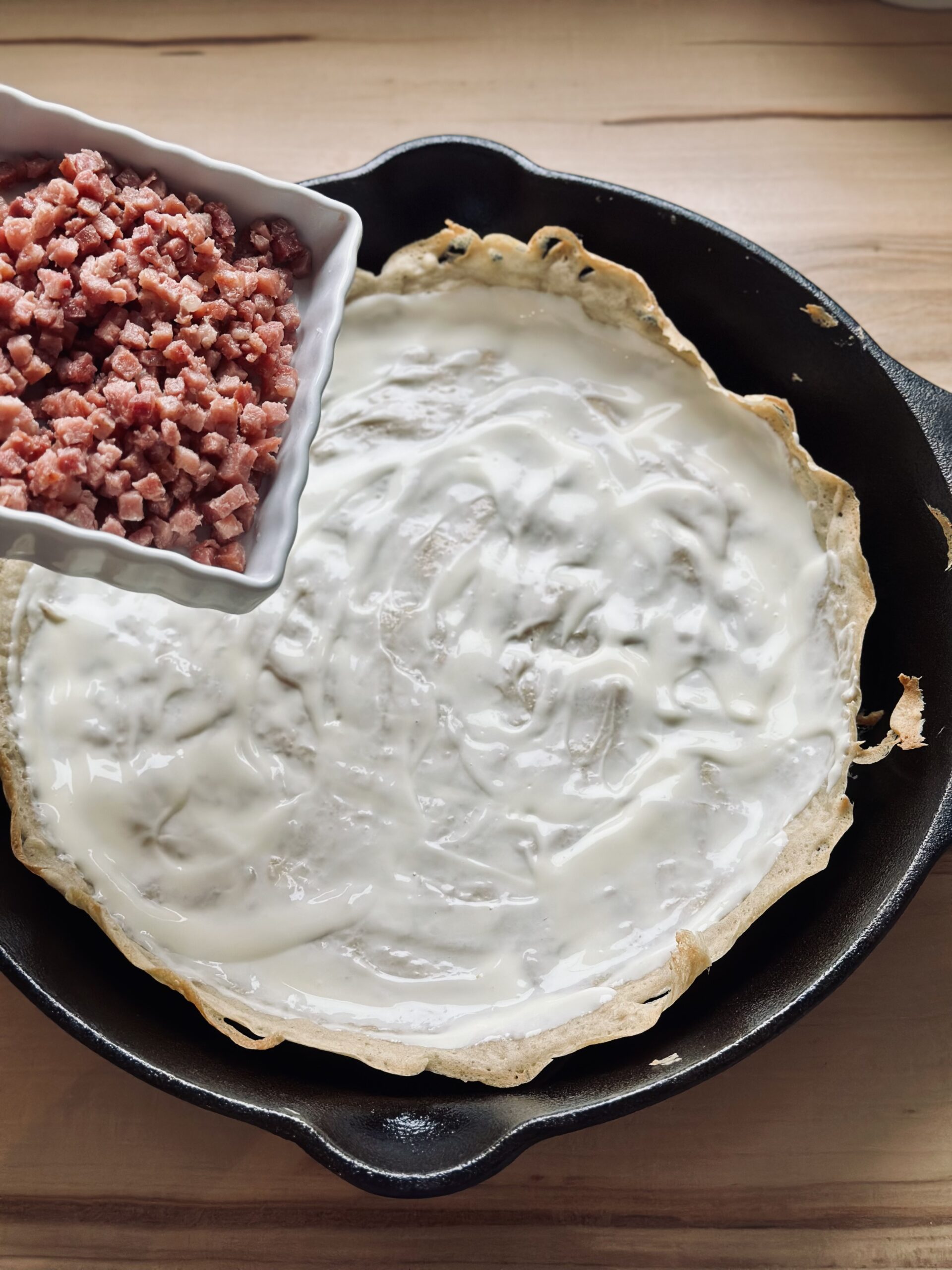 Speck auf dem Flammkuchen verteilen