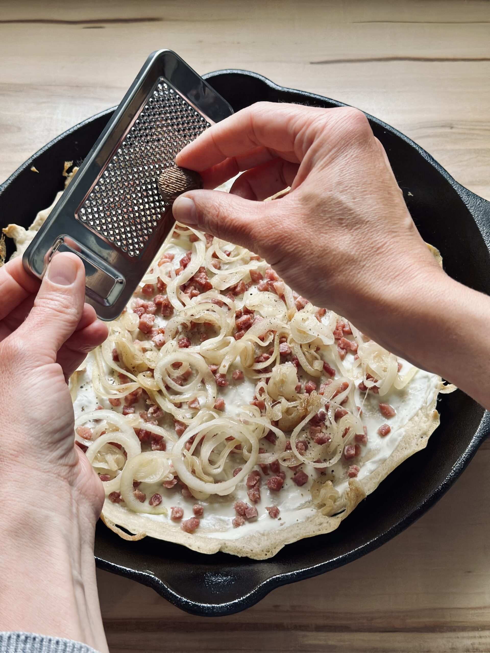 Optional Muskatnuss über dem Flammkuchen streuen