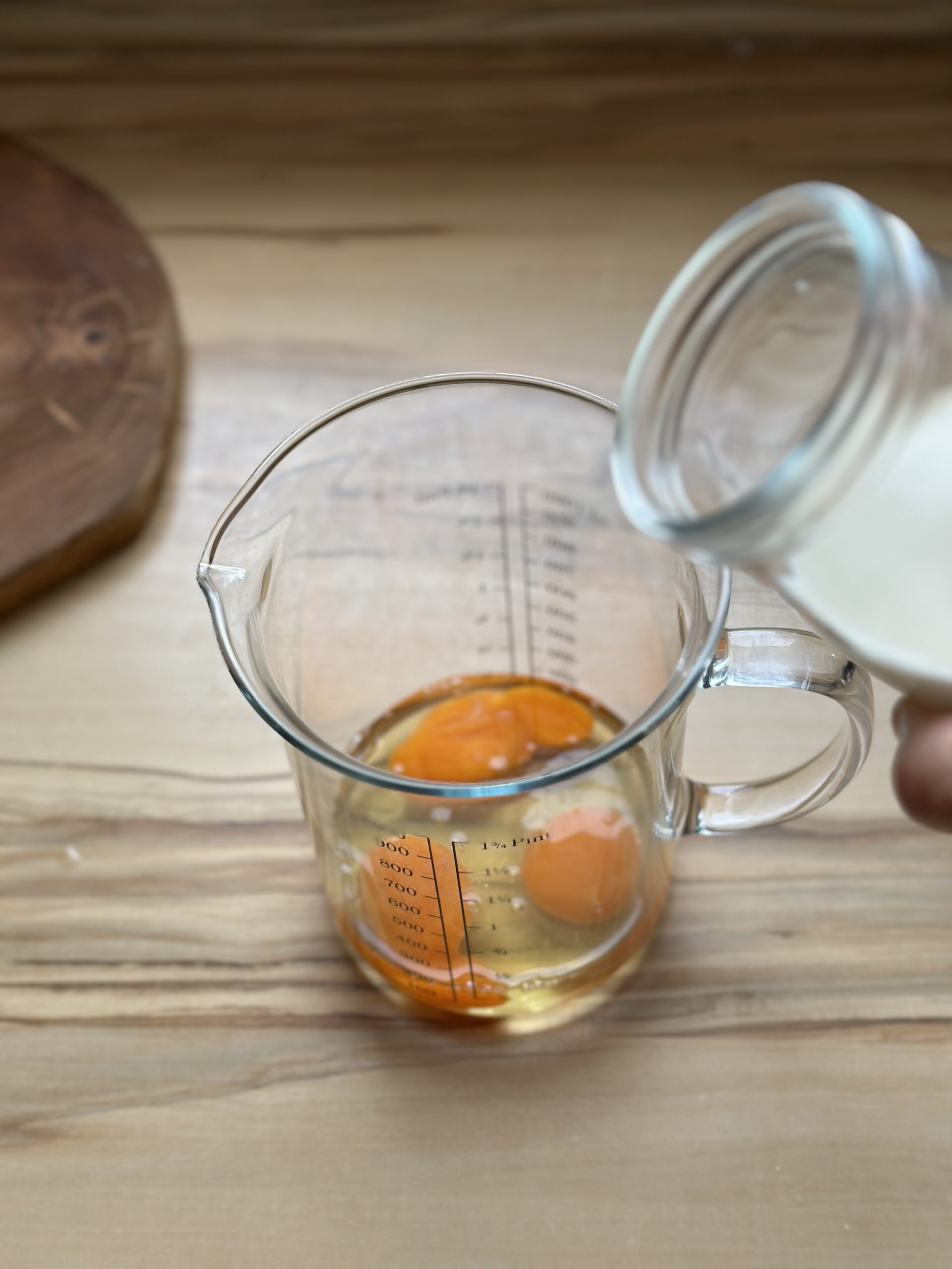Eier und Sahne in ein Messbecher geben