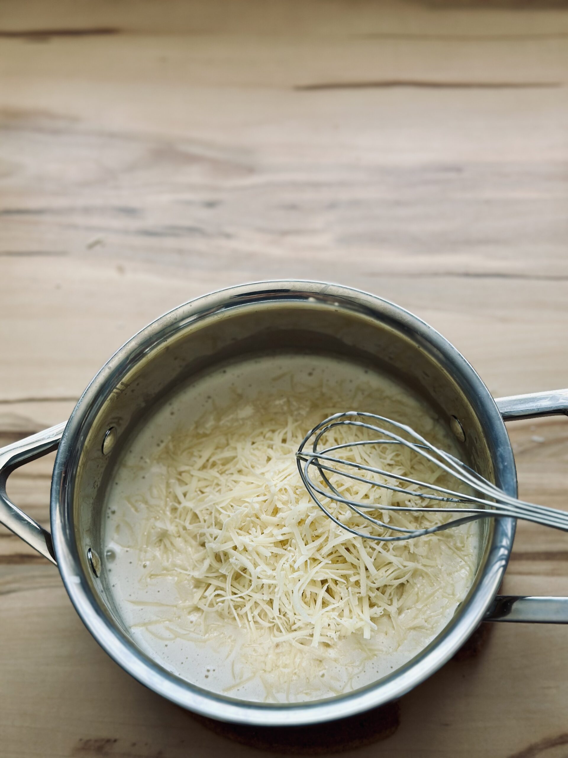 Käse in die Soße einrühren und köcheln lassen