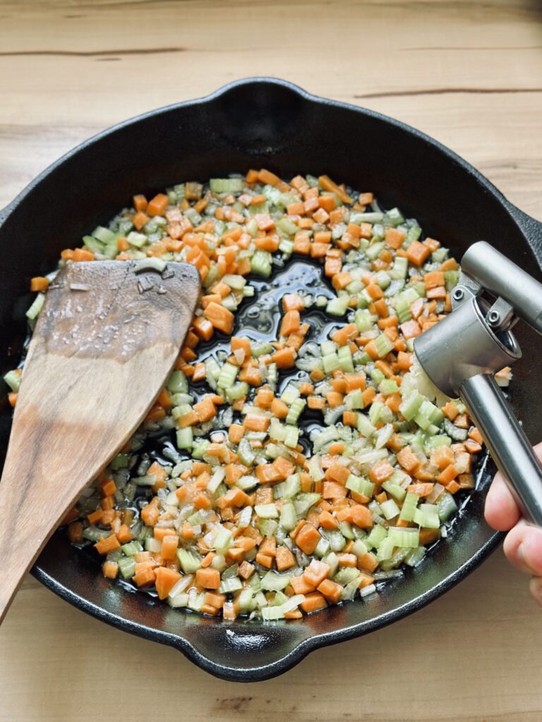 Knoblauch zu dem Gemüse hinzufügen
