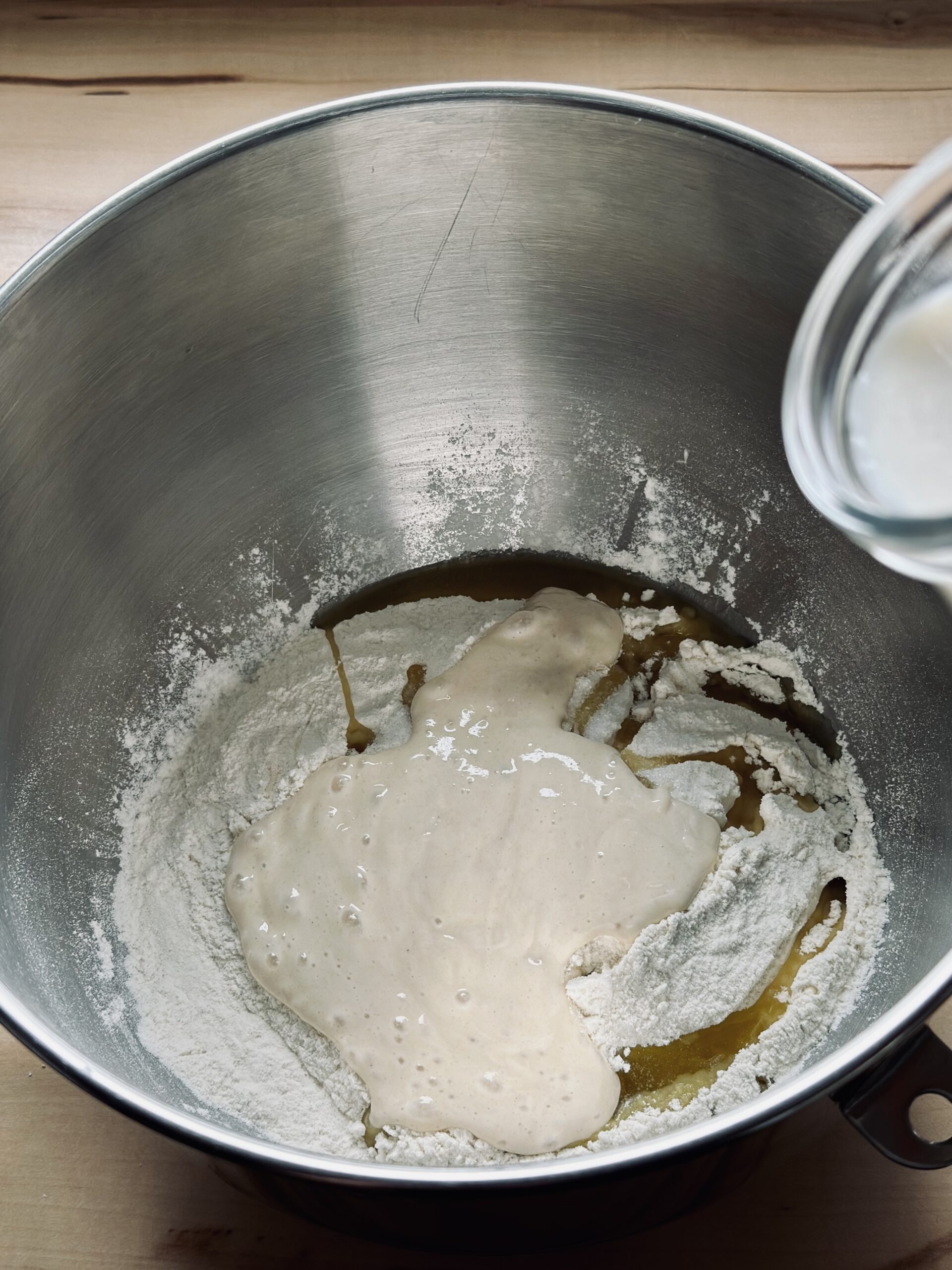 Sauerteigrest zu der Mehlmischung geben und Milch/Hefemischung dazugeben