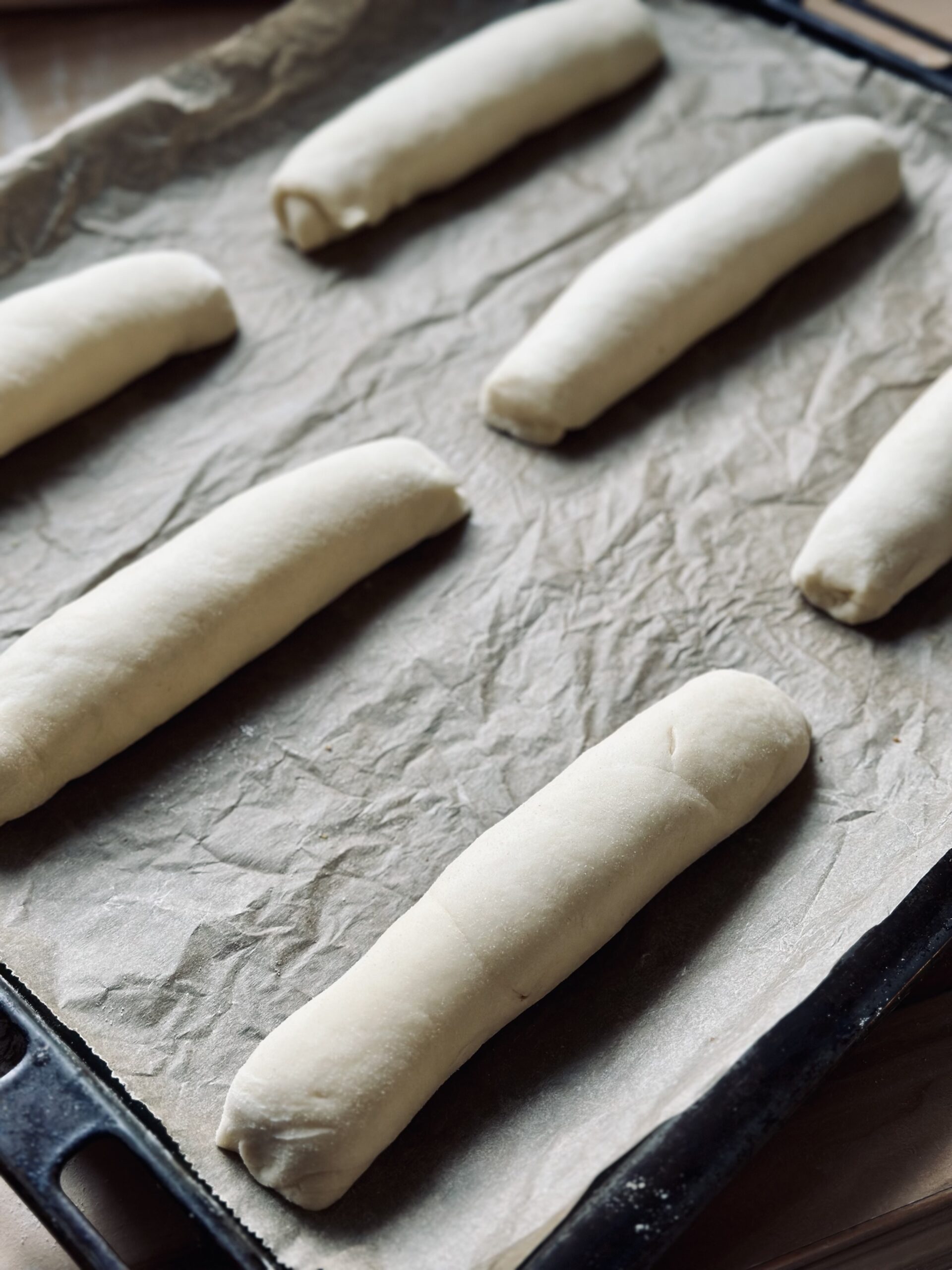 Sauerteig Hot Dog Brötchen auf einem Backblech gehen lassen