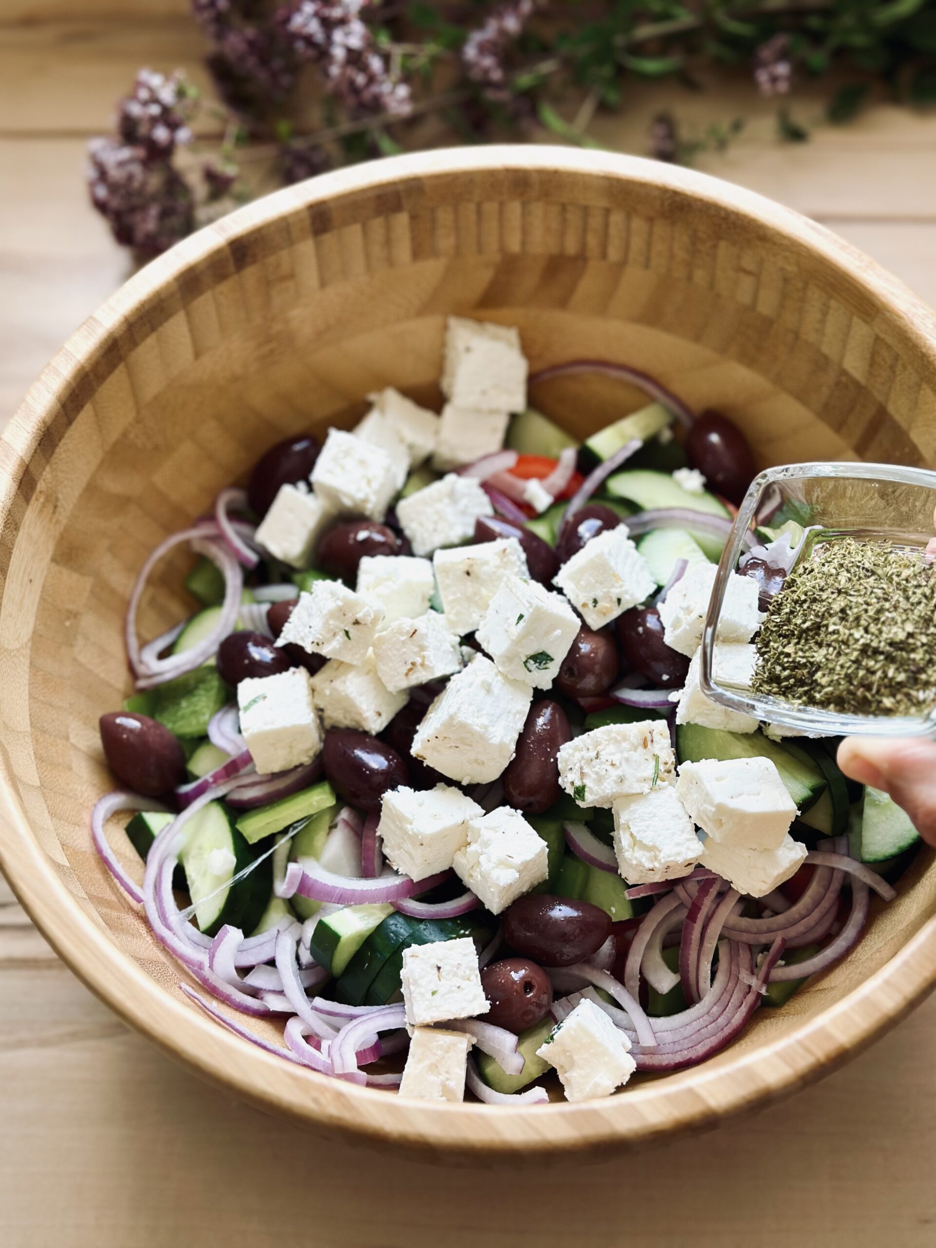 Oregano über den Salat streuen