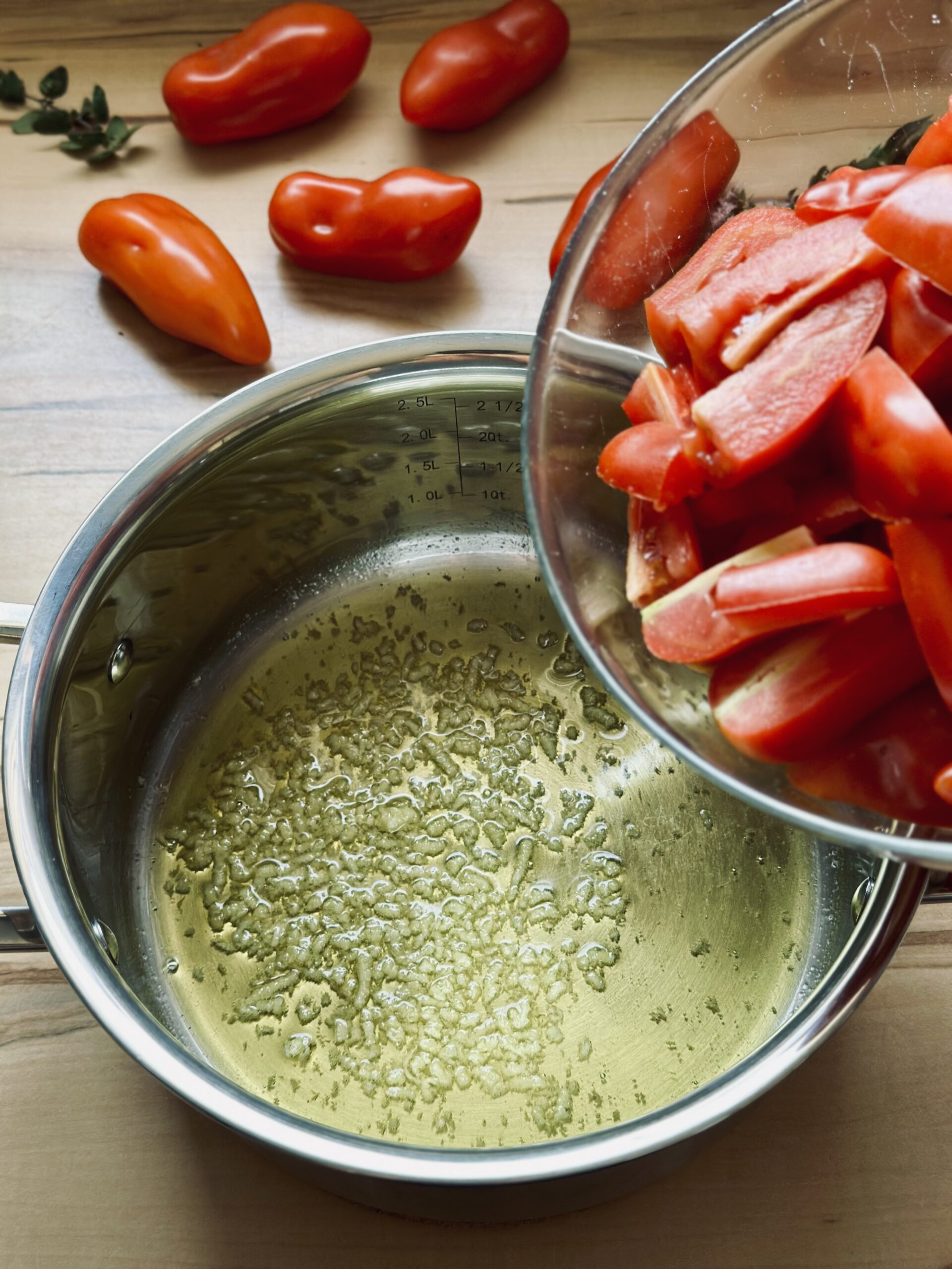 Tomaten zu dem Knoblauch geben