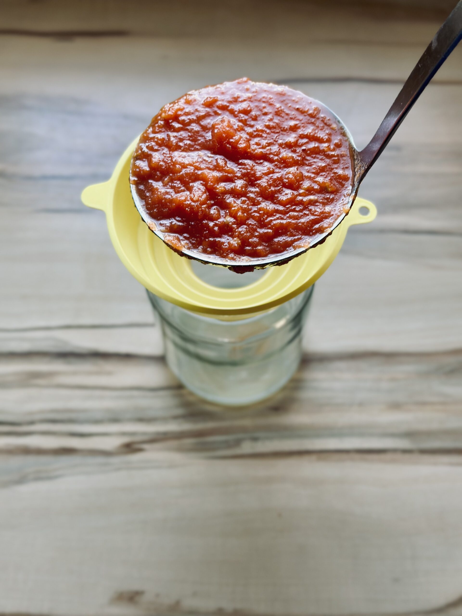 Heiße Tomatensoße in das Einmachglas geben