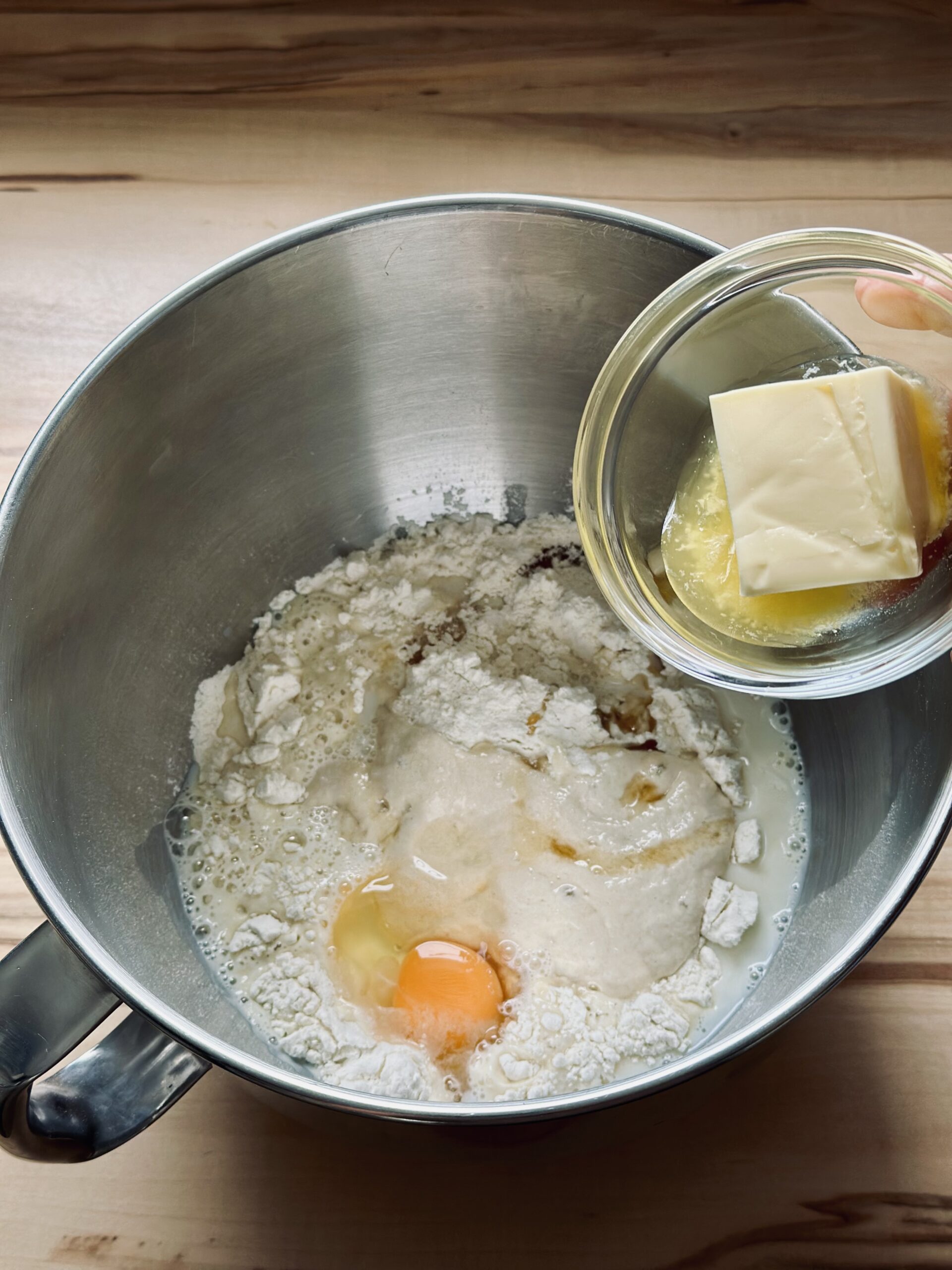 Weiche Butter in den Teig geben und gut verkneten lassen bis ein glatter elastischer Teig entstanden ist