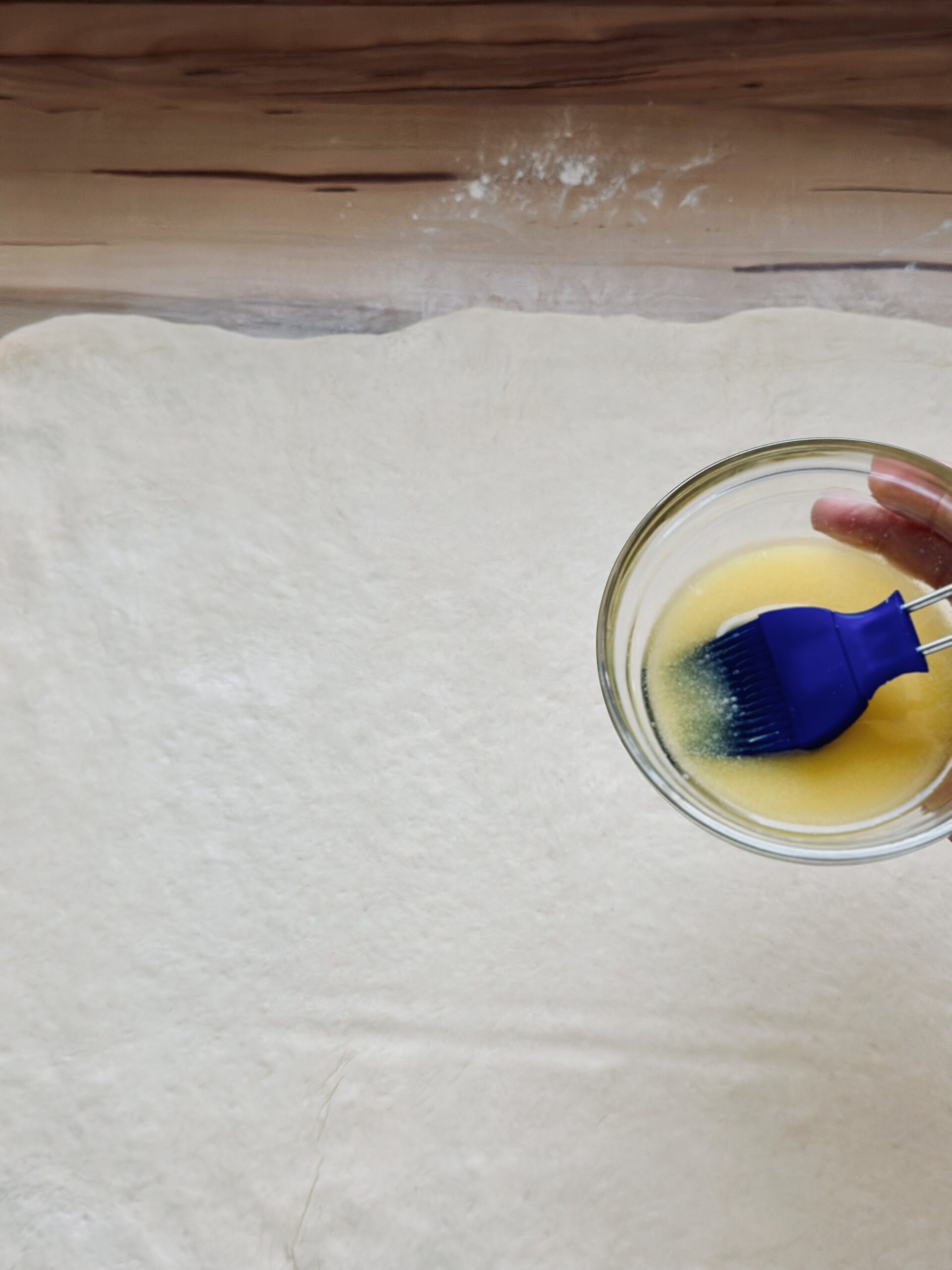 Flüssige Butter auf dem Teig verteilen