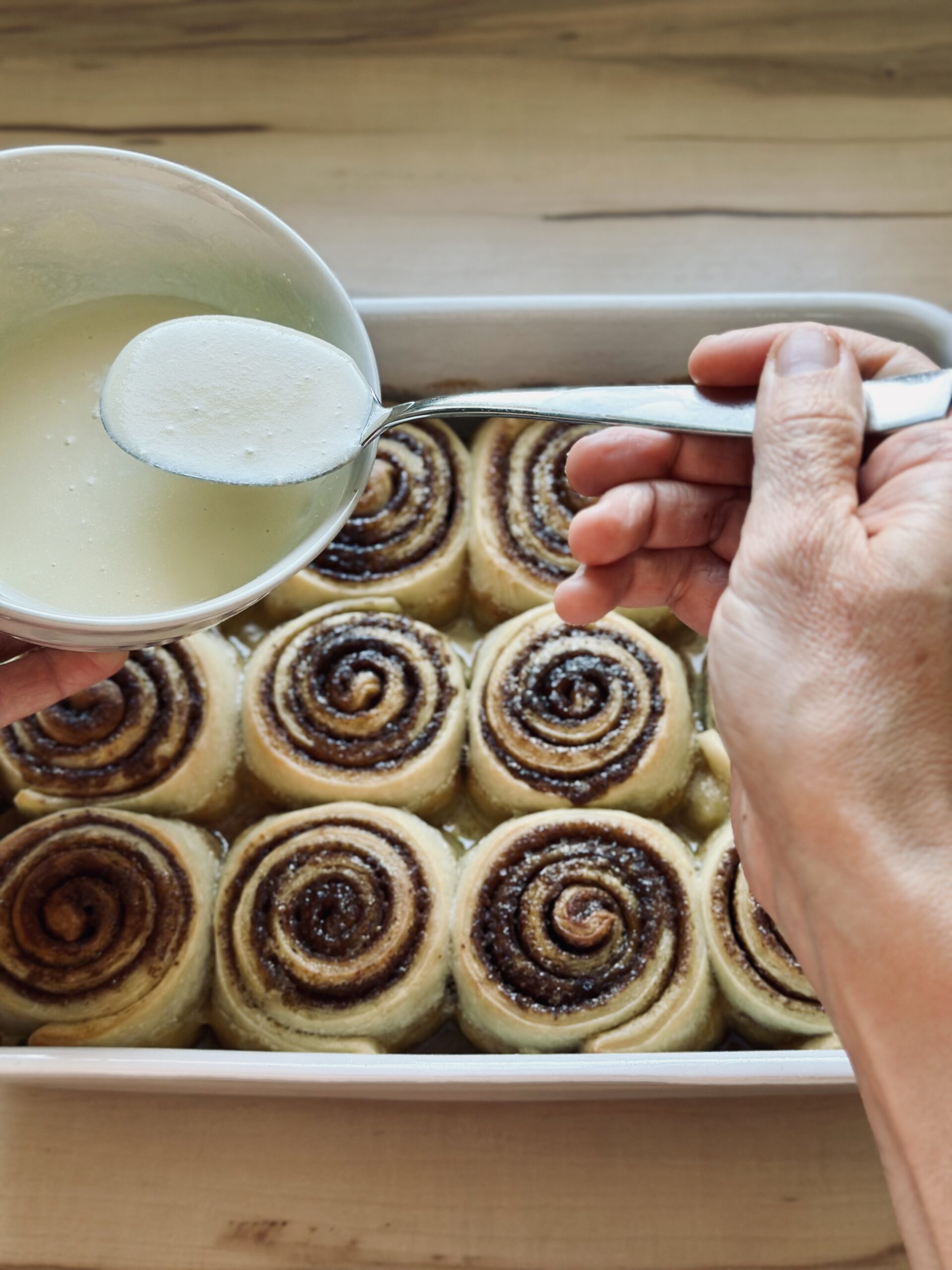 Soße über den Zimtschnecken verteilen
