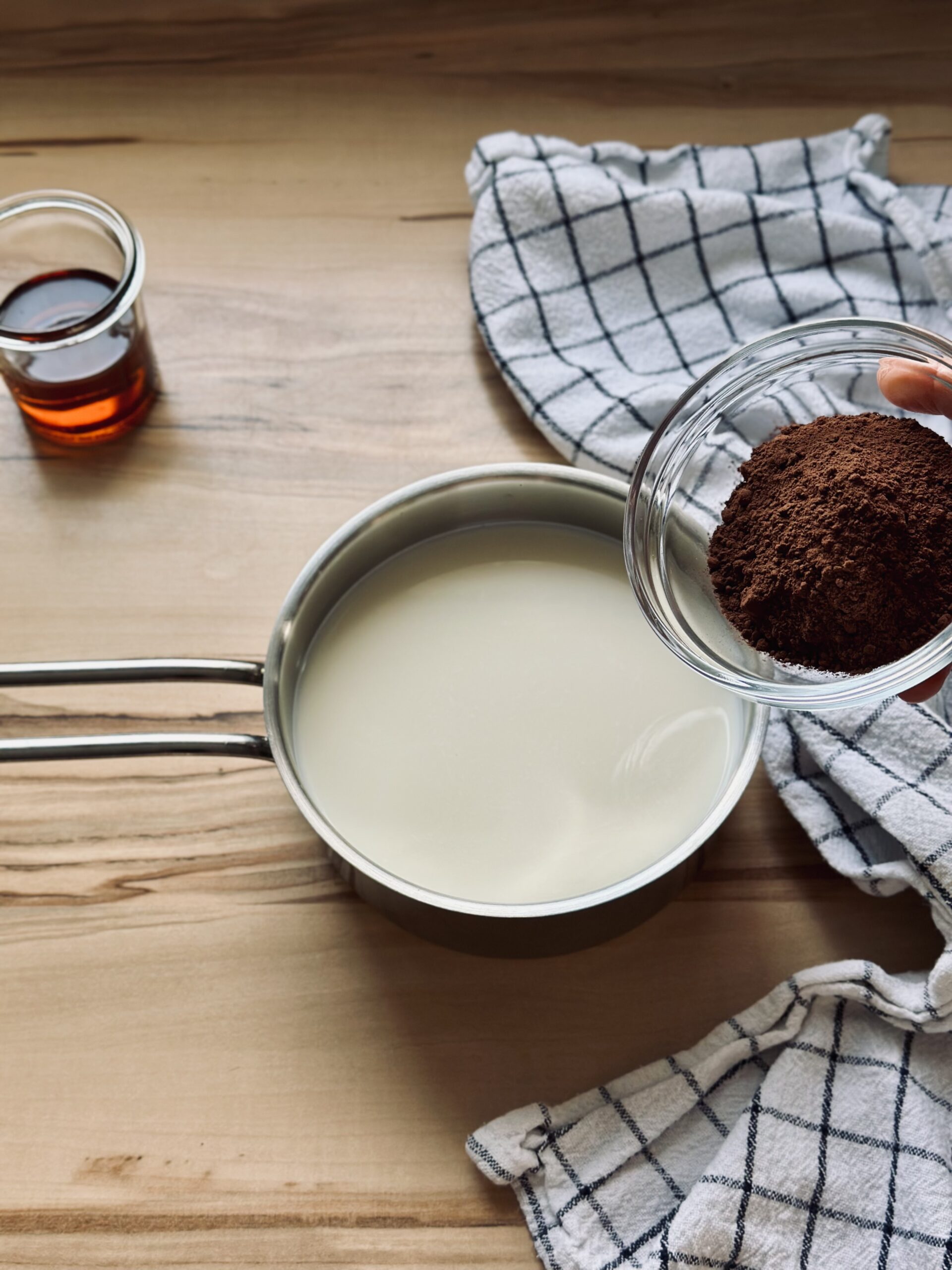 Kakaopulver zu der Milch hinzufügen
