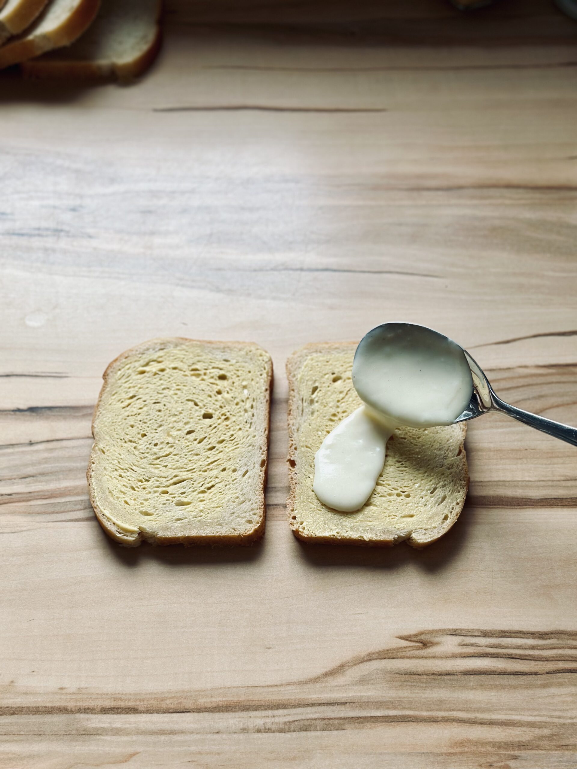 Béchamelsoße auf die Brotscheiben streichen