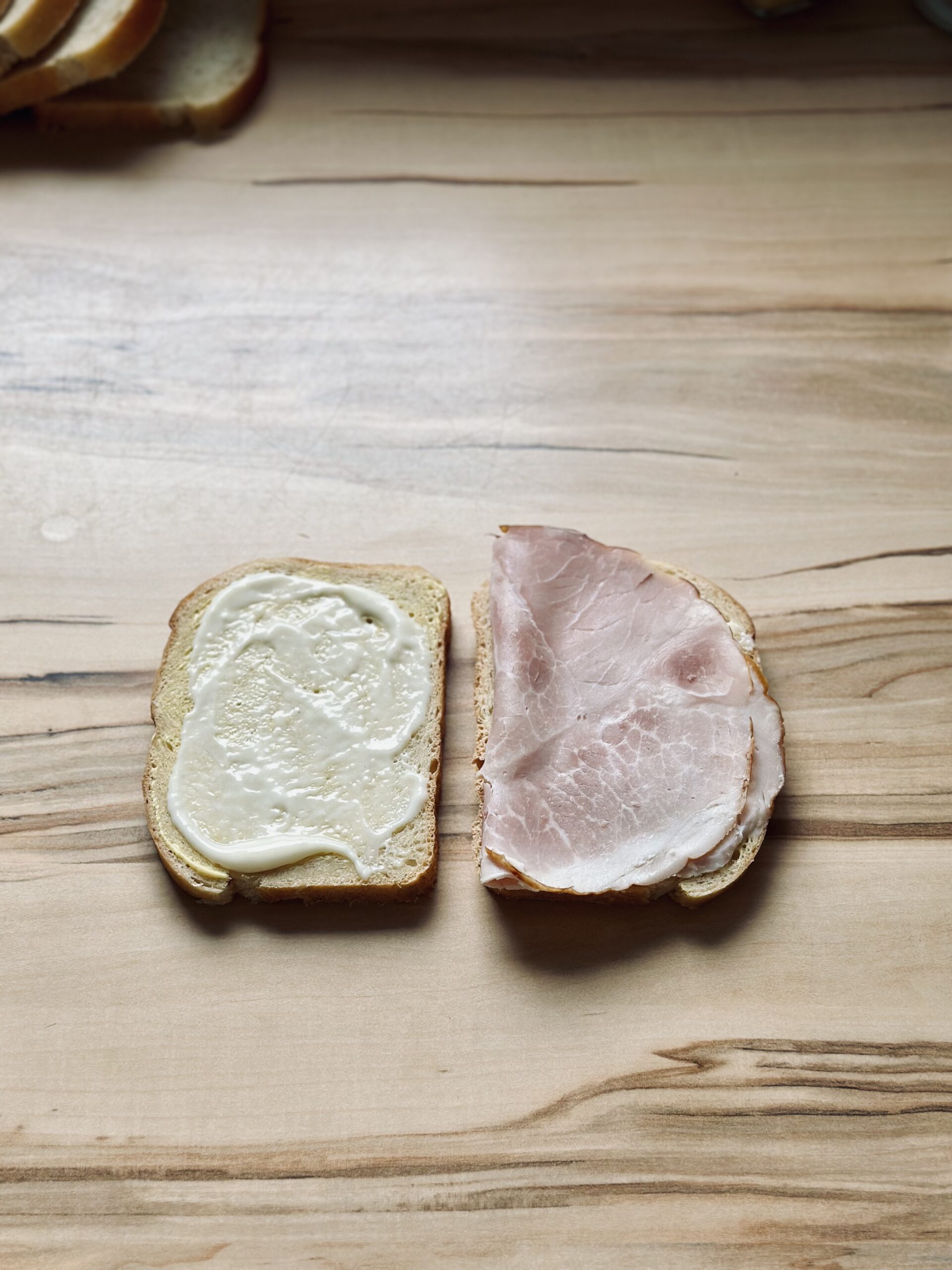 Schinken auf das Brot legen