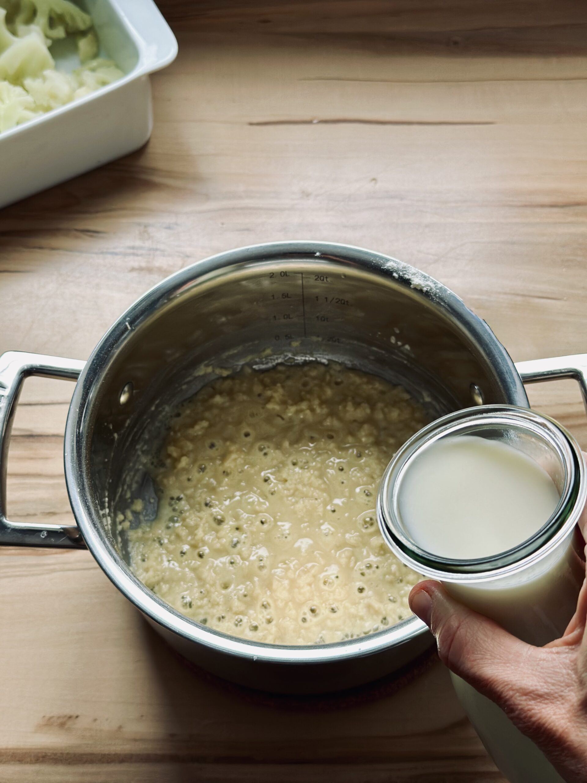 Etwas von der Milch zu dem Mehl und der Butter geben und gut verrühren