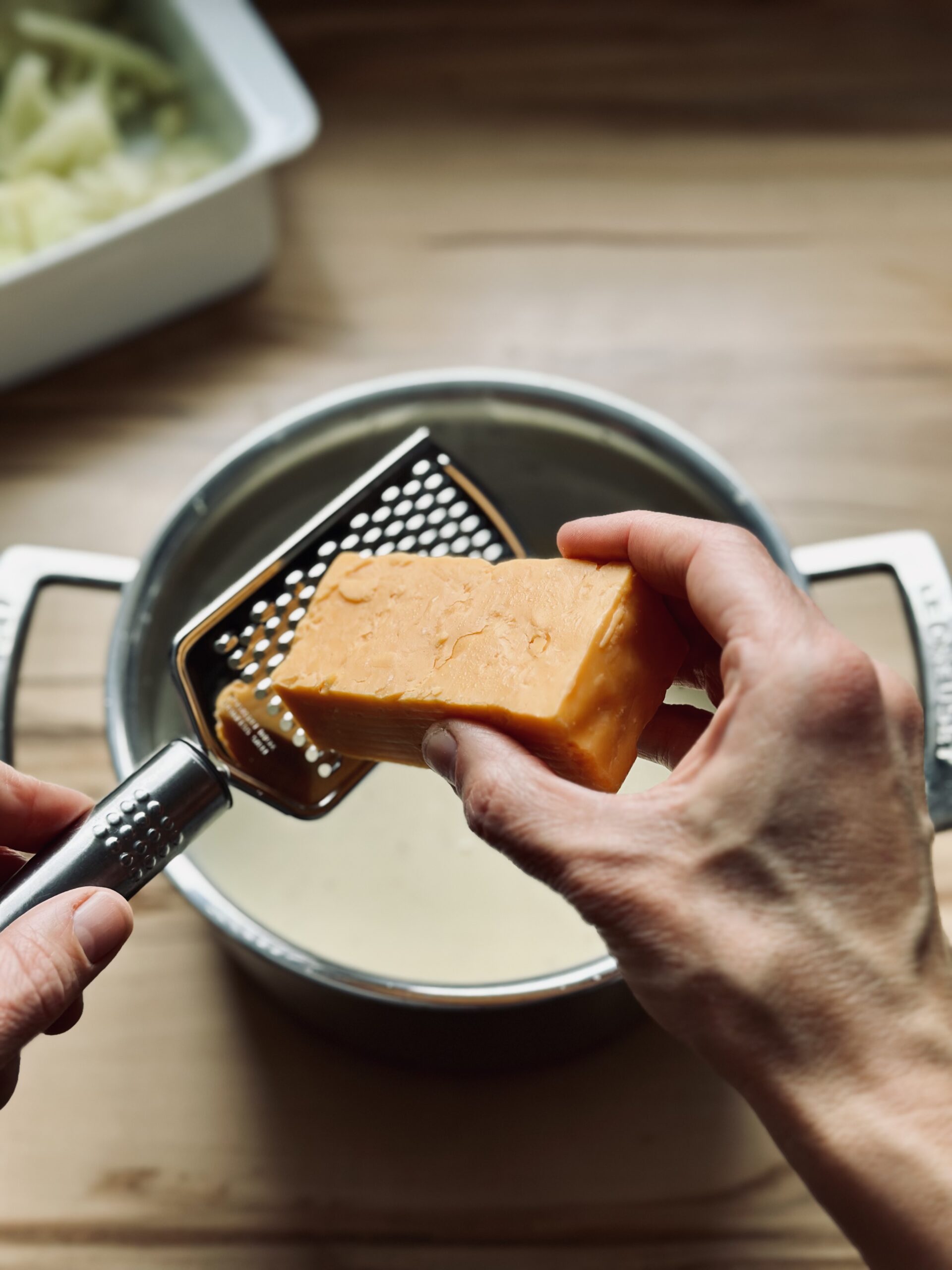 Käse in die Soße reiben