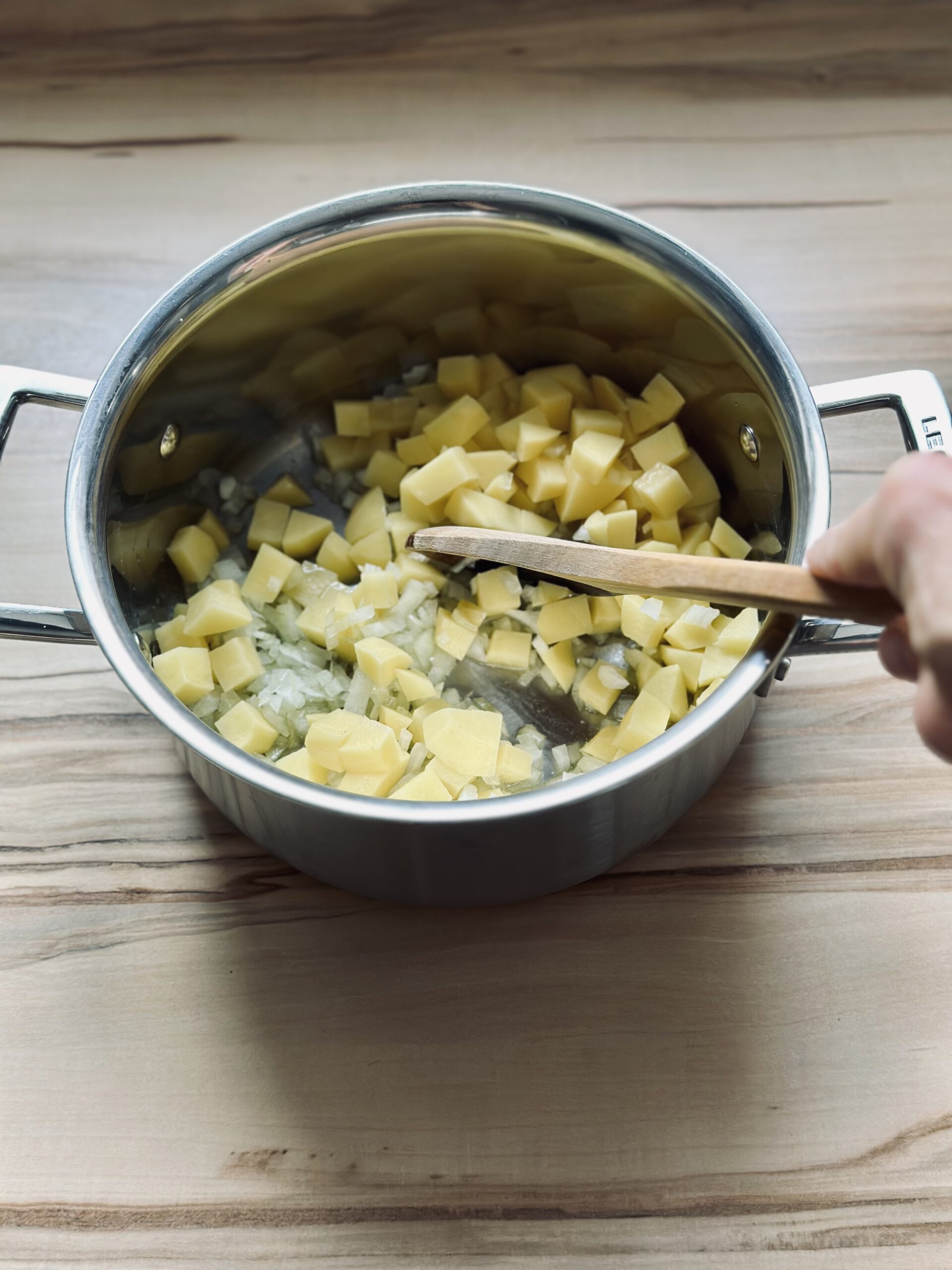 Kartoffeln und Zwiebeln andünsten