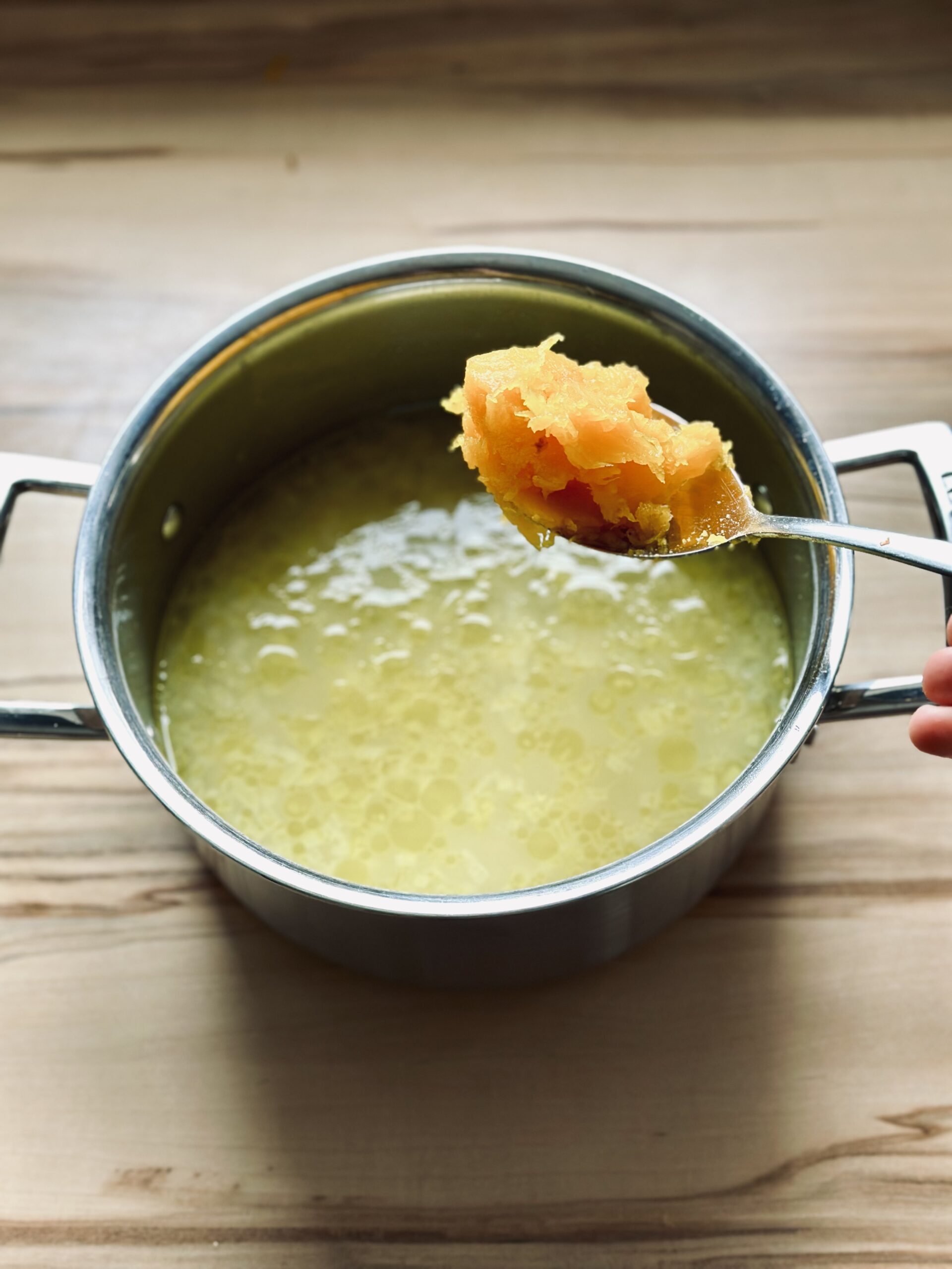 Kürbispüree zu der Suppe geben