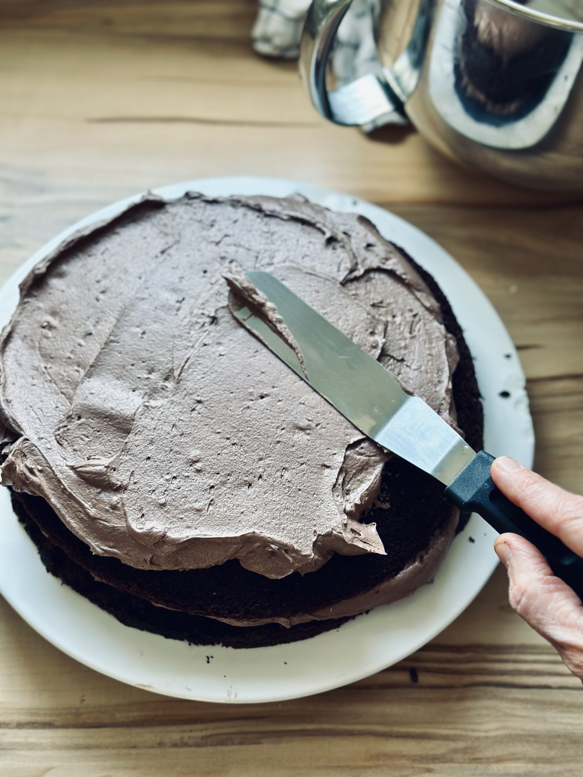 Schokoladen-Buttercreme auf dem Sauerteig-Schokoladenkuchen verteilen