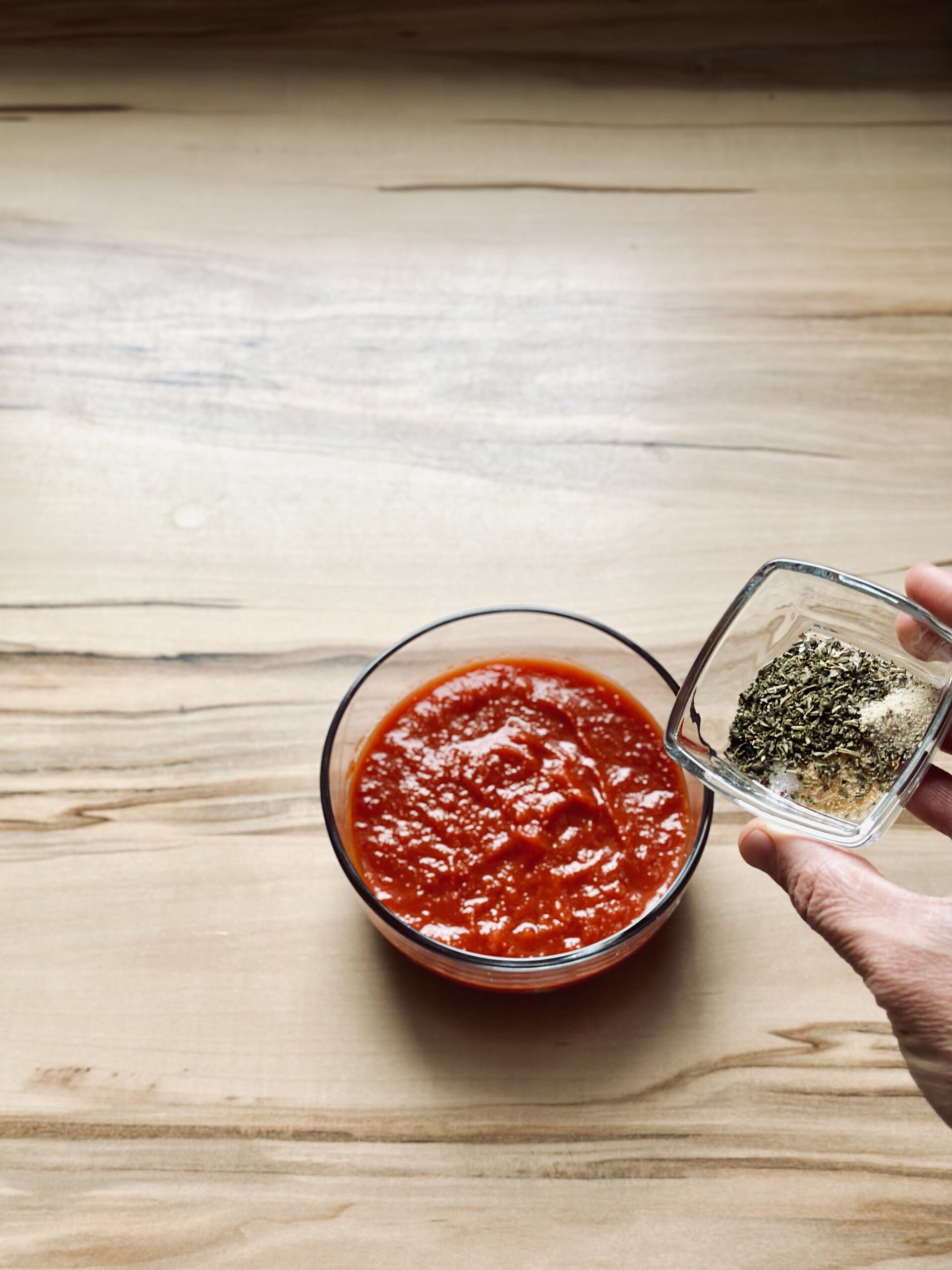 Kräuter mit Tomatensoße vermengen