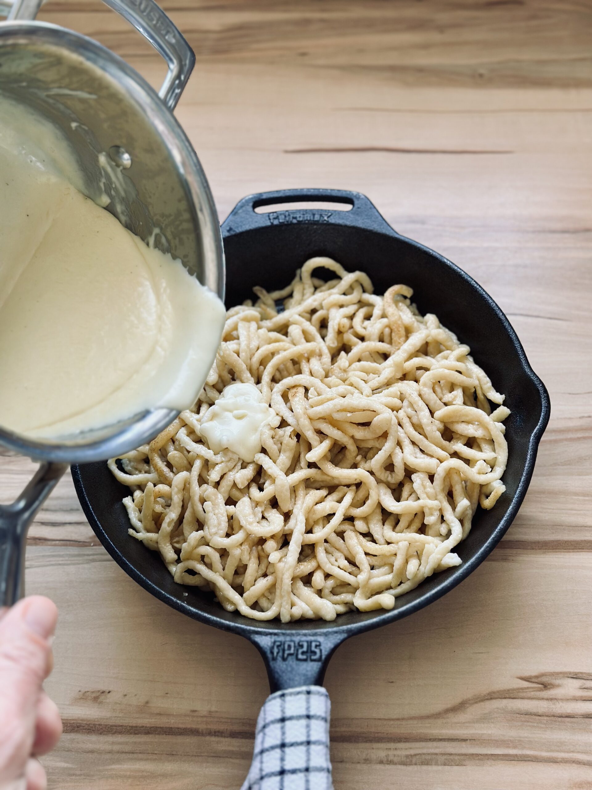 Soße über die Spätzle geben