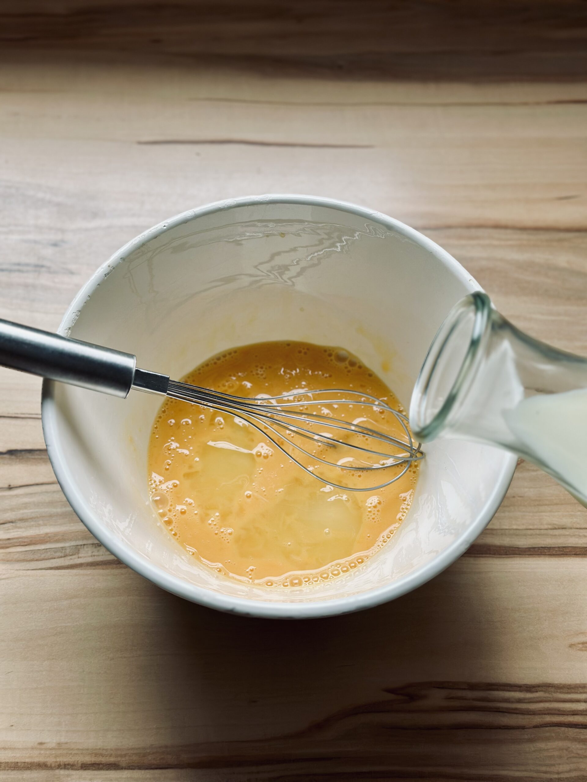 Milch zu den Eiern geben und gut verrühren
