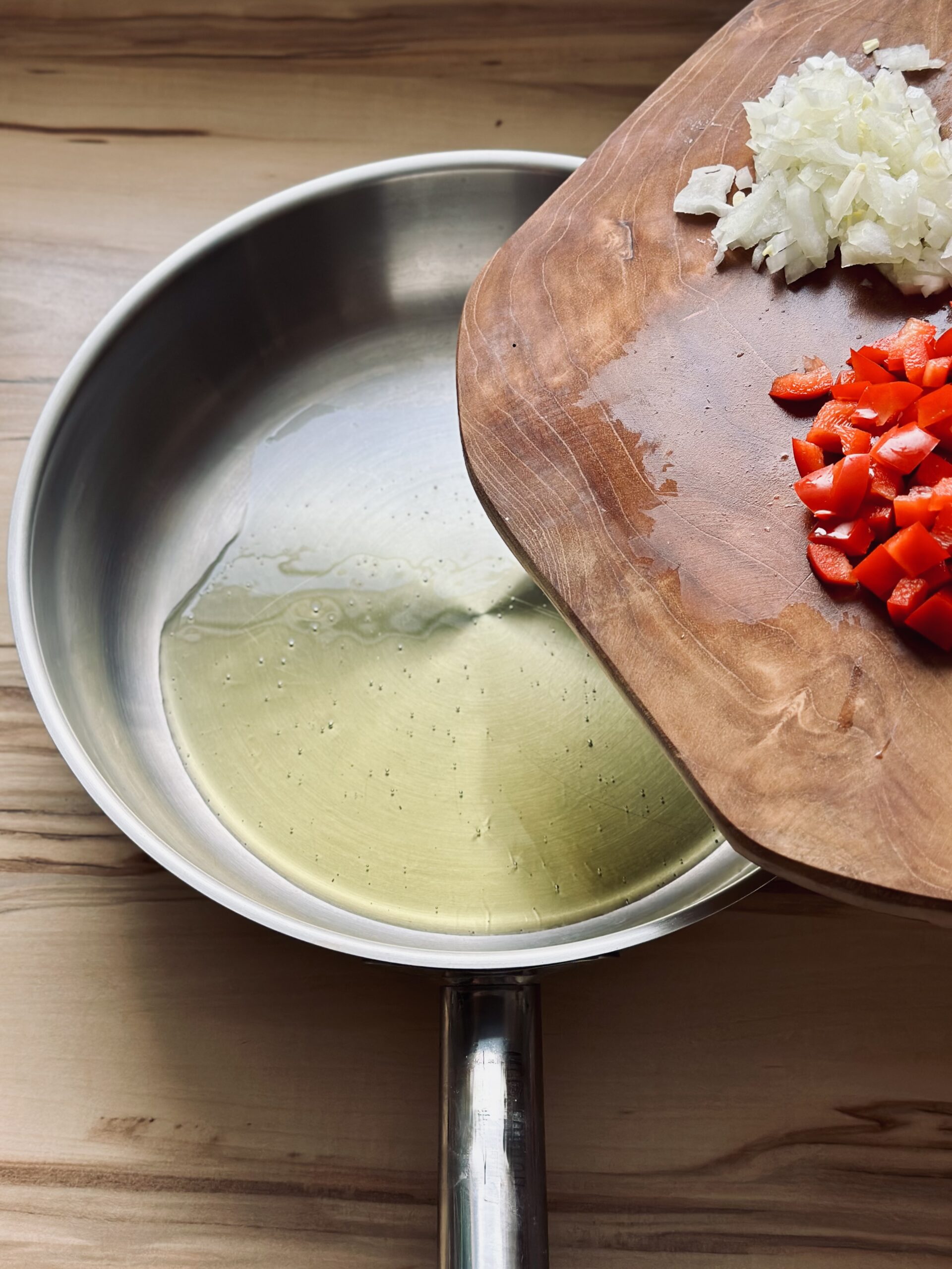 Zwiebeln und Paprika zu dem Öl geben und etwas andünsten