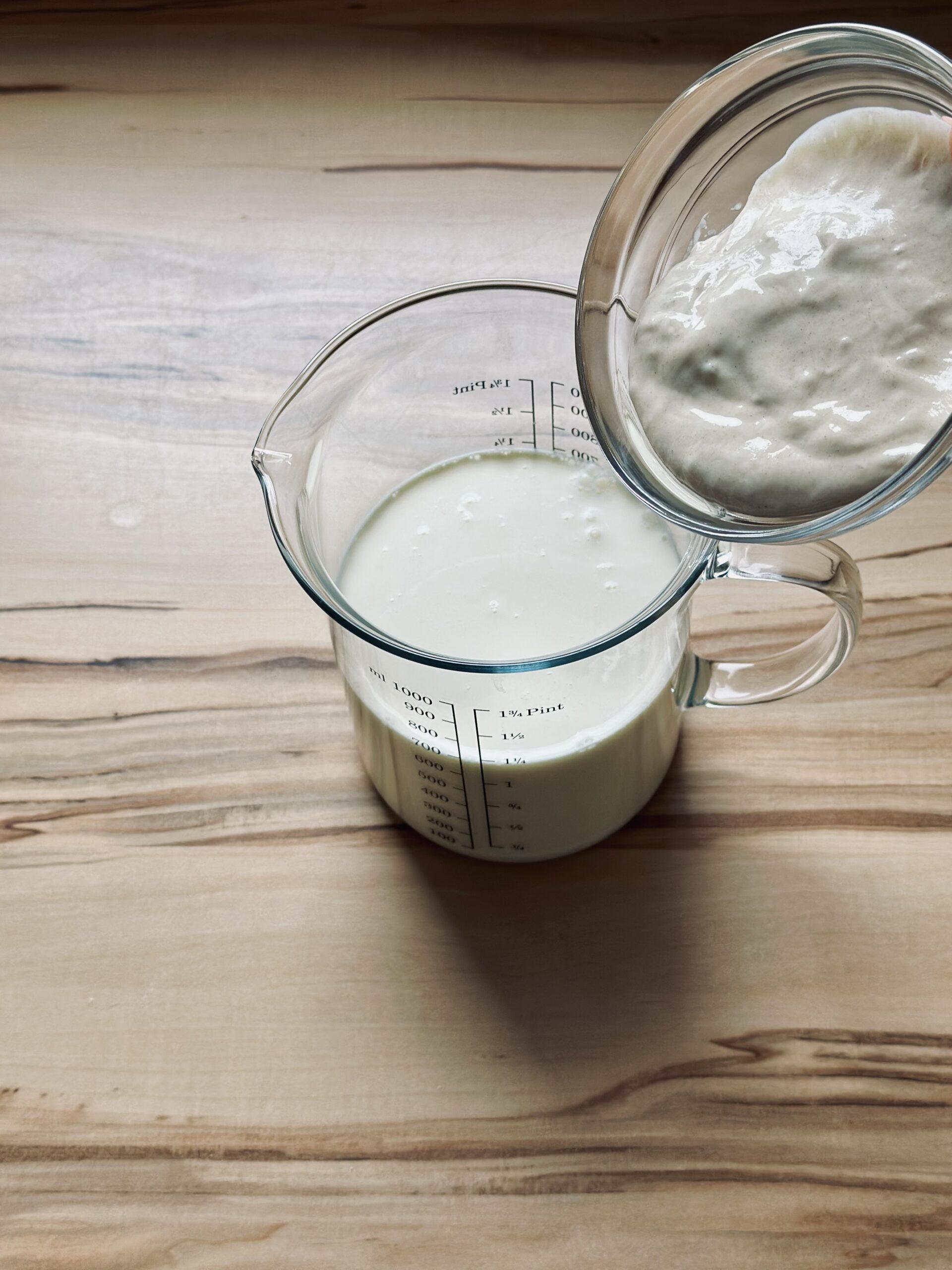 Sauerteig zu der Milch-Sahne-Mischung hinzugeben