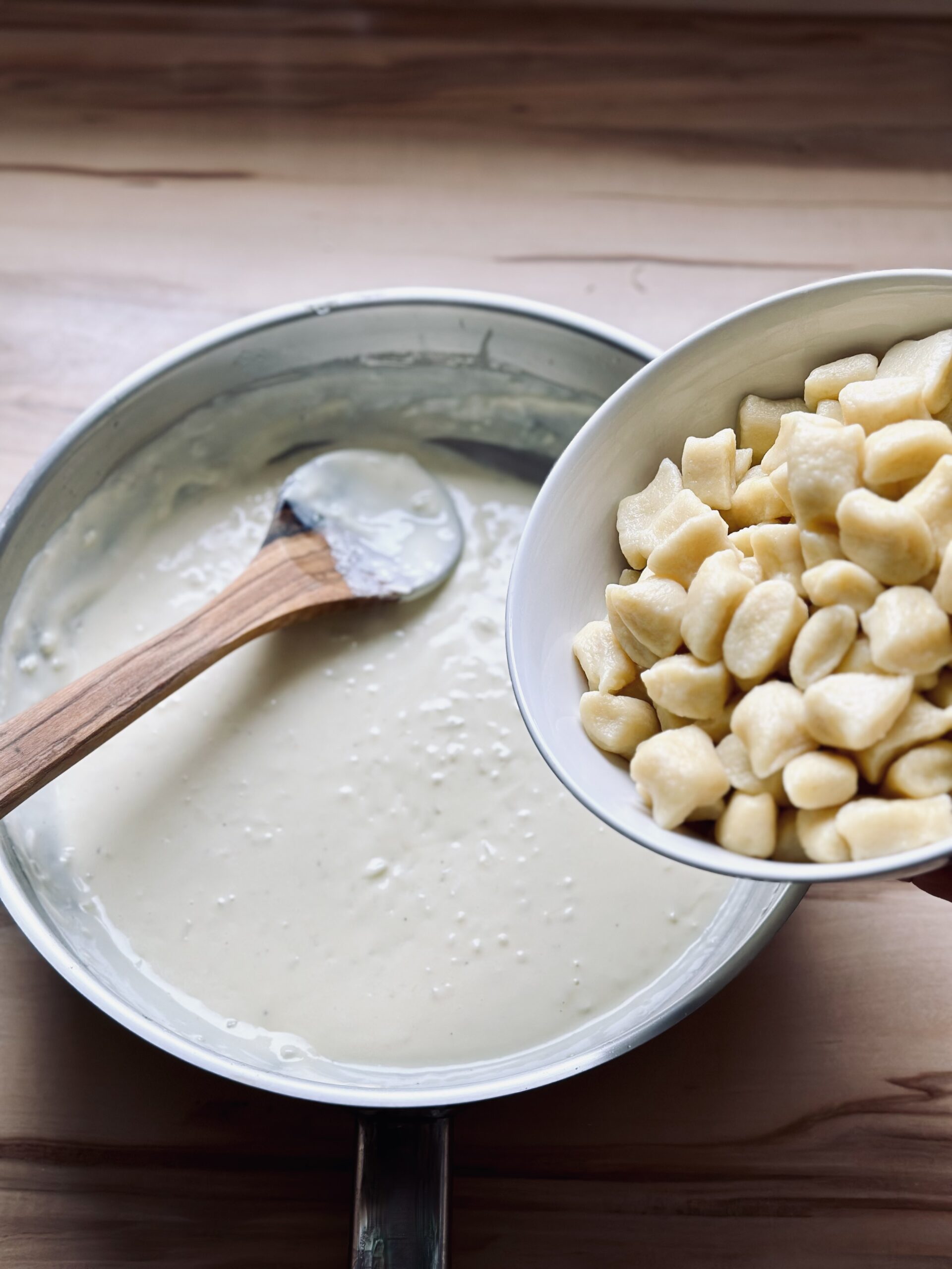 Gnocchi in die cremige Käse-Sahne Soße geben und einrühren