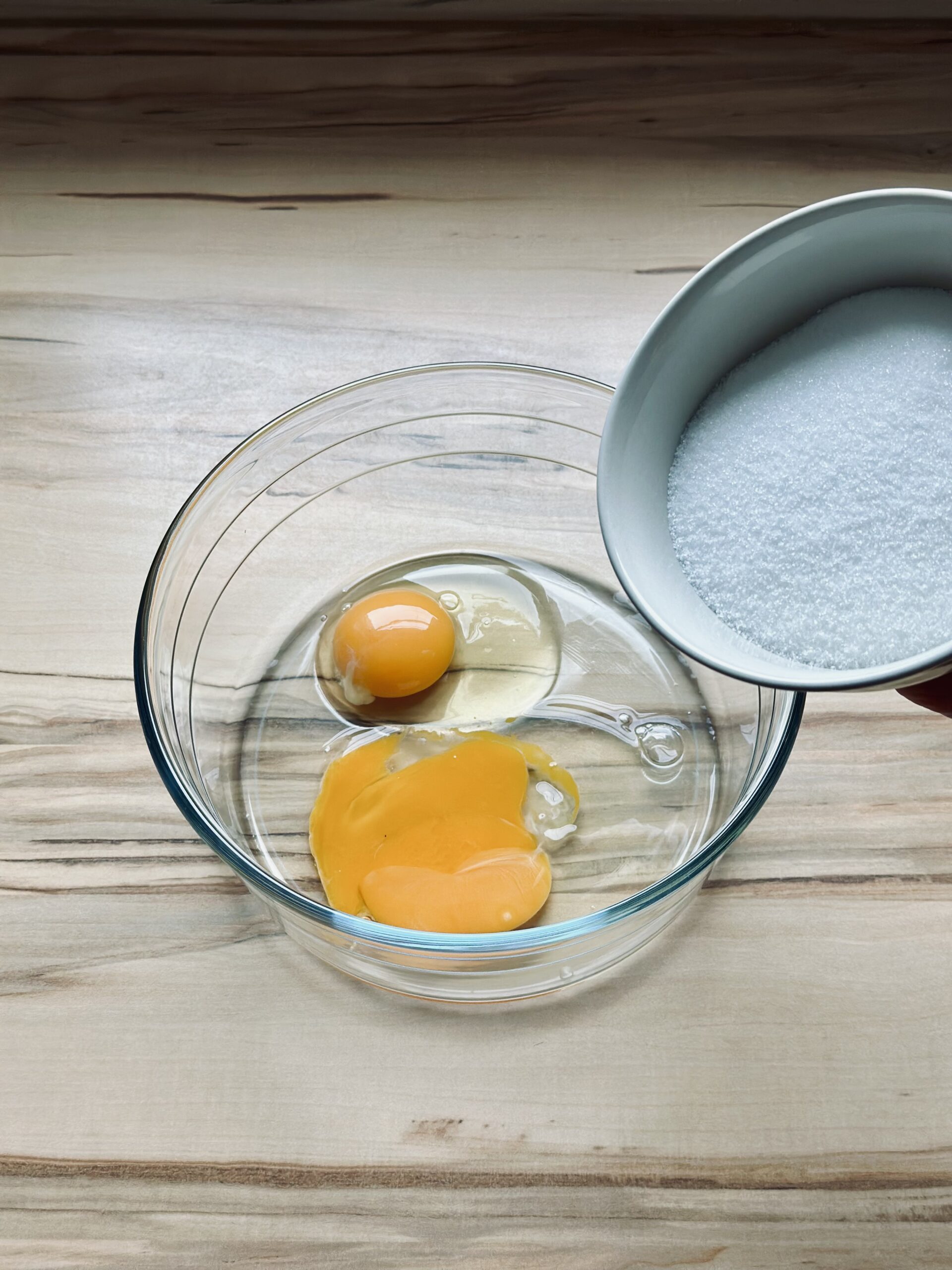 Zucker zu den Eiern hinzugeben