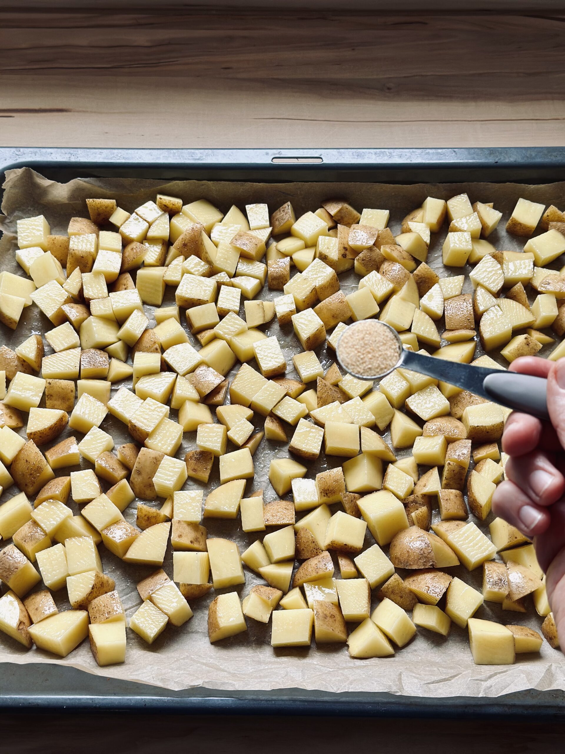 Optional Knoblauchpulver über die Kartoffeln geben