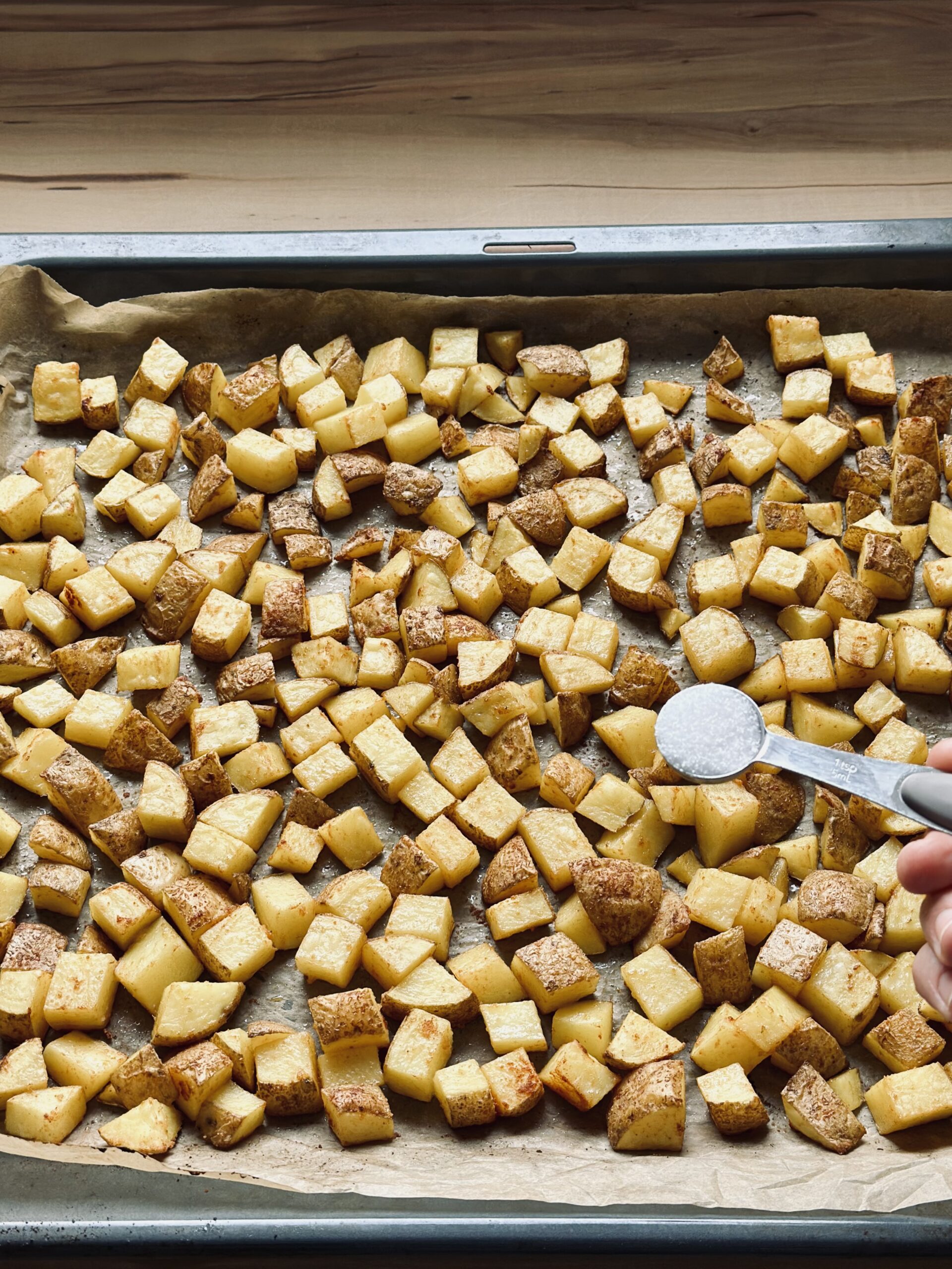 Salz über die Kartoffeln geben